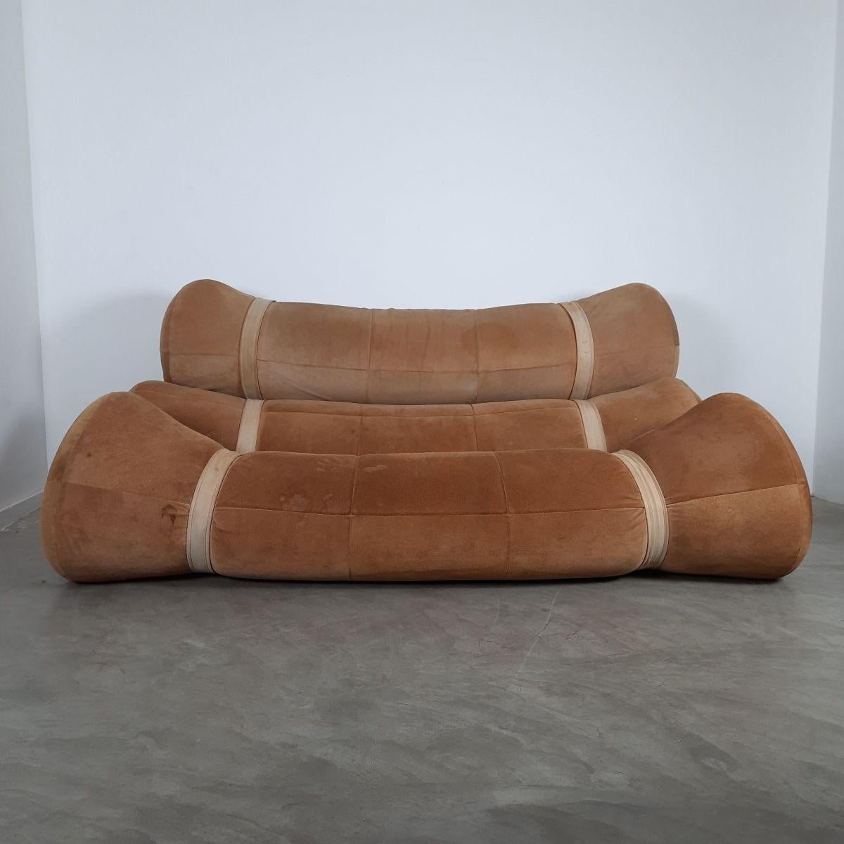 Extremely comfortable vintage Fardos sofa by the Brazilian designer Ricardo Fasanello. This is his first creation made in 1968. It consists of three large rolls of foam held together by straps on painted metal base structure. Upholstered with brown