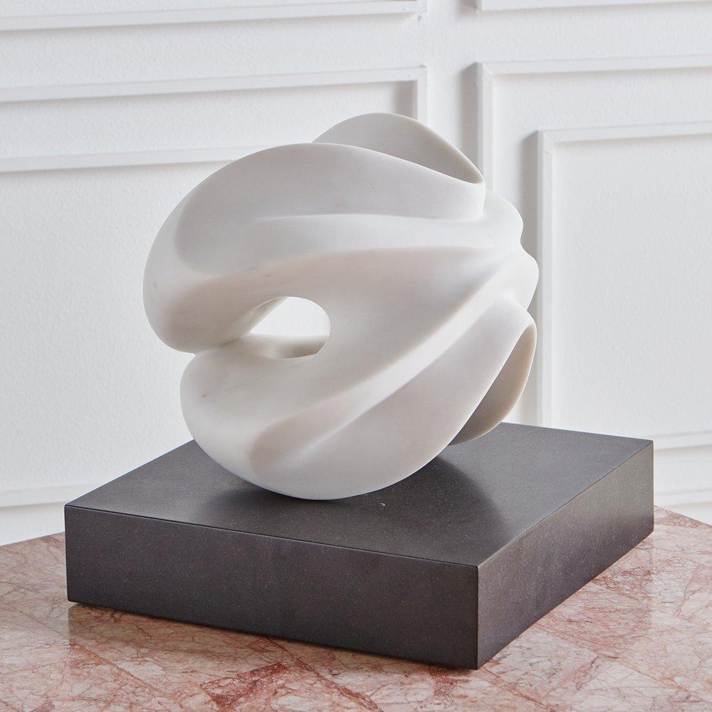 The Farfalle Sphere sculpture by Chicago artist Karl Geckler. This piece was hand carved from a white marble with a honed finish and is mounted on a black granite base.

Karl Geckler works as an interdisciplinary sculptor, architect, and designer