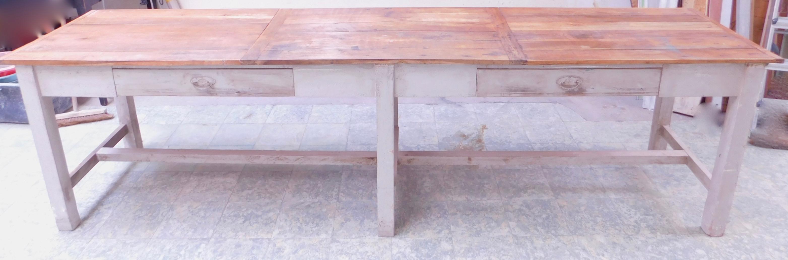 Rustic Hungarian farmhouse table with two-drawers can be used for dining or as a long console table.
Retaining the original handles and many coats of old paint (mainly ivory white)on the base and a paneled oak board top, circa 1920. 