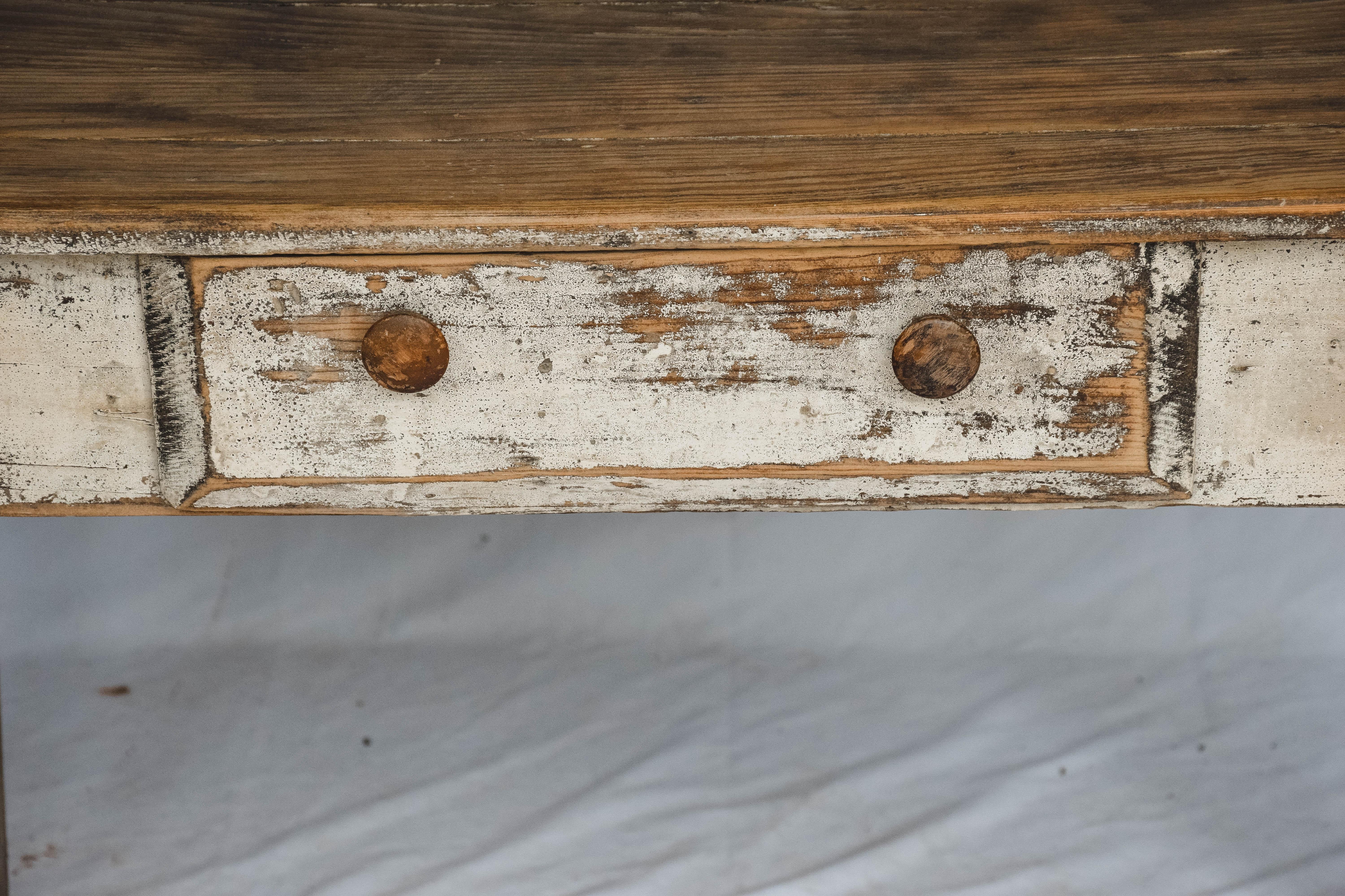 This handmade farm table features one drawer and some paint leaving a wonderful patina. We love the simplicity of this early 20th century piece.