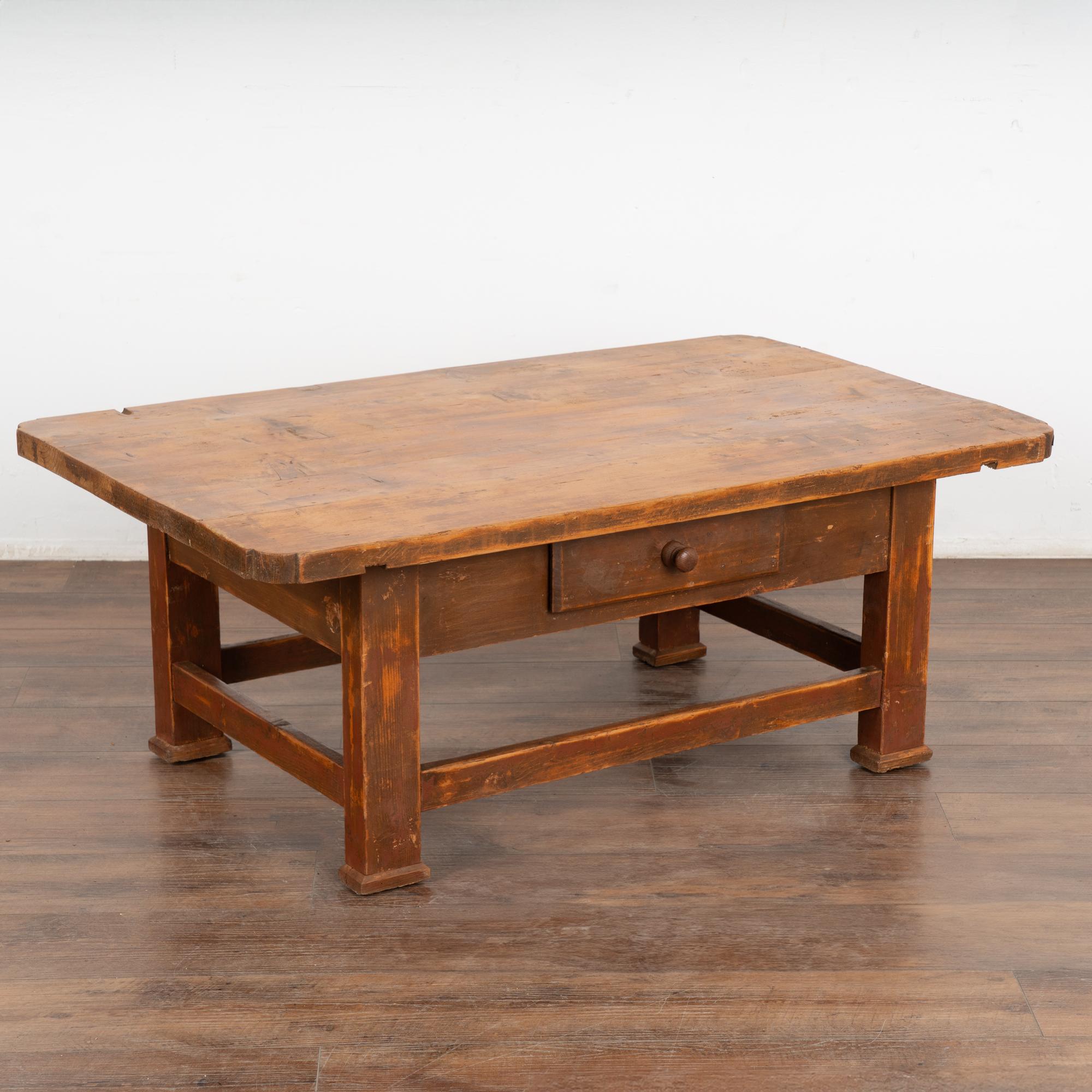 Farmhouse charm meets modern functionality in this pine coffee table from Europe. The original brown/brick paint has been distressed and worn down to reveal the natural pine below.
Every nick, scratch and gouge add to the character and appeal of