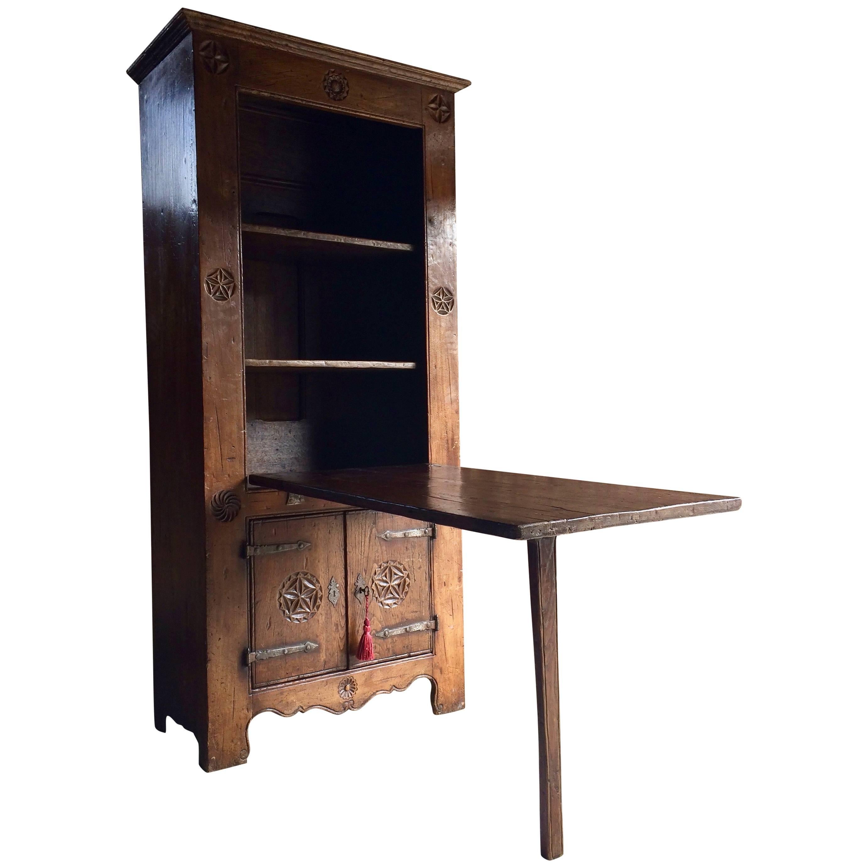 Rare 16th century style Dutch solid oak cupboard featuring a drop-down farmhouse table, the corniced top over a single drop down door with original hand forged iron hinges, the door with a single swing down leg that drops down to form a table, two