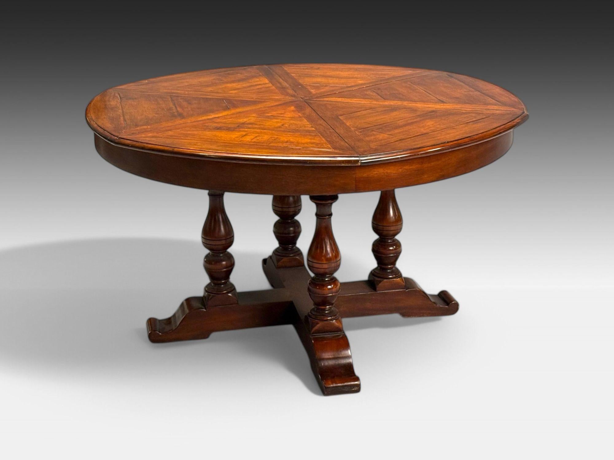 Farmhouse Style, Walnut Jupe Expandable Round Dining Table, USA, 20th c.

This Walnut Jupe dining table is crafted with a sophisticated farmhouse patterned top and is supported on four turned wood uprights leading to the trestle style base. This