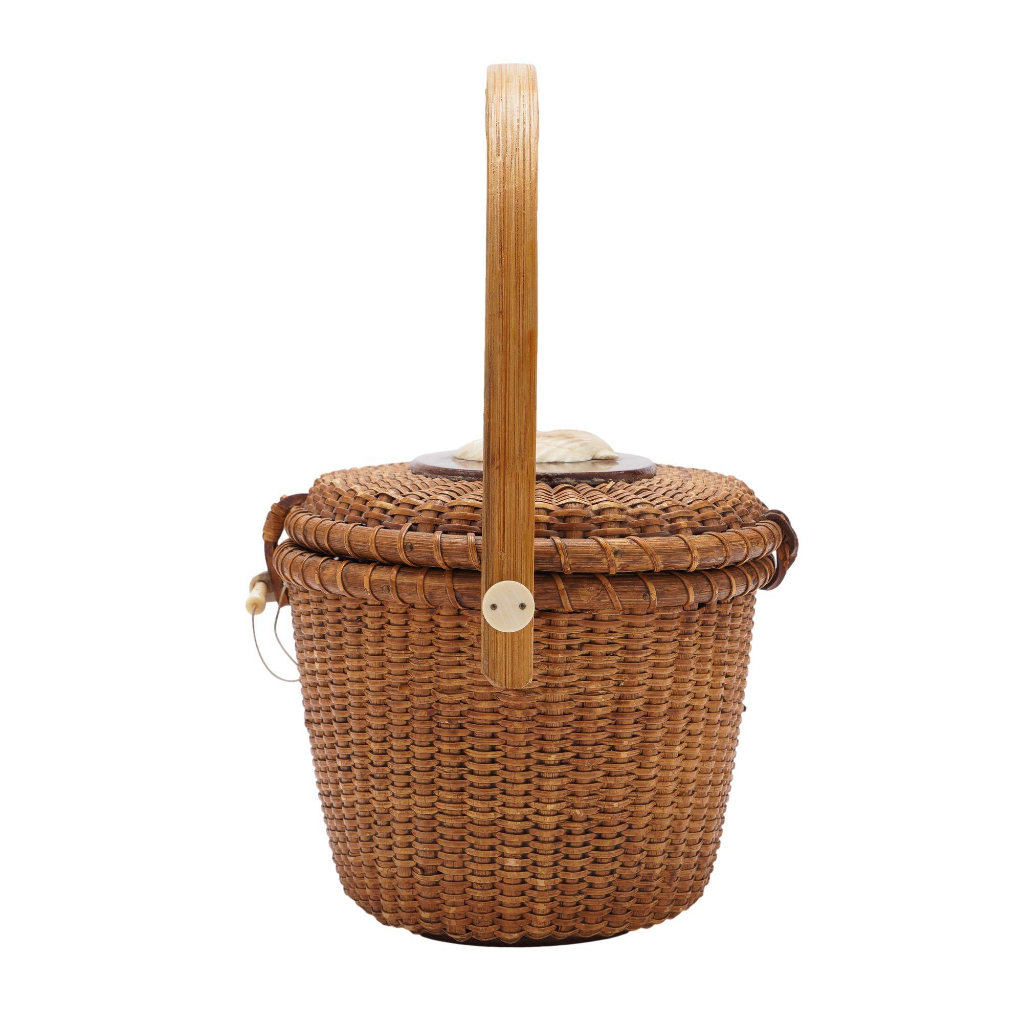 Woven split bamboo handbag with walnut foot and lid. The lid is fitted with a carved scallop shell.
Signed and dated on the underside: Farnum, 1979

Nantucket, Rhode Island, 1979.

Dimensions: 9