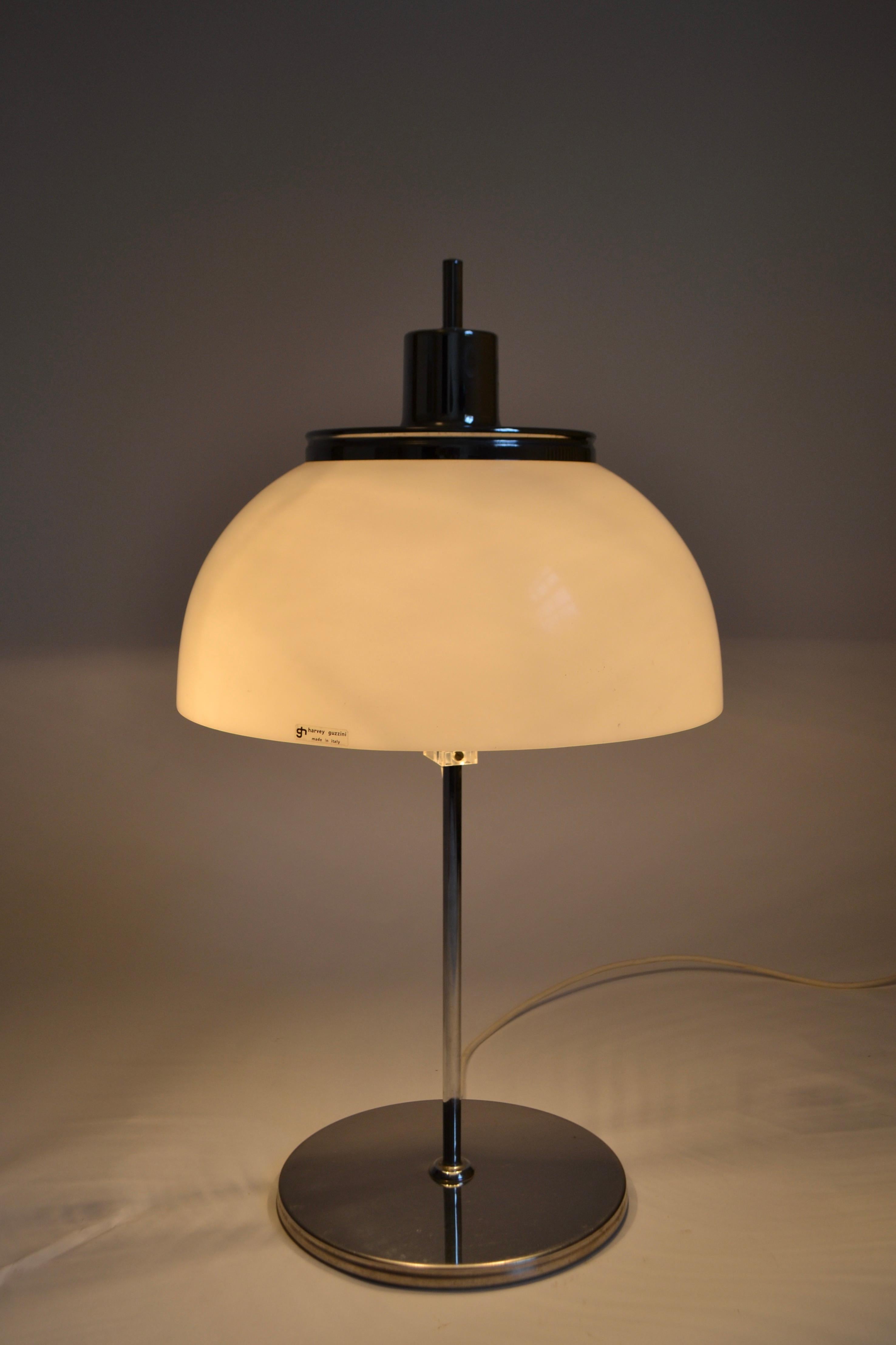 1970s Harvey Guzzini mushroom style Faro table lamp. Chrome plated with white acrylic shade. Height of shade is adjustable as it can move up and down the central column. Original Guzzini sticker still on shade. UK plug.