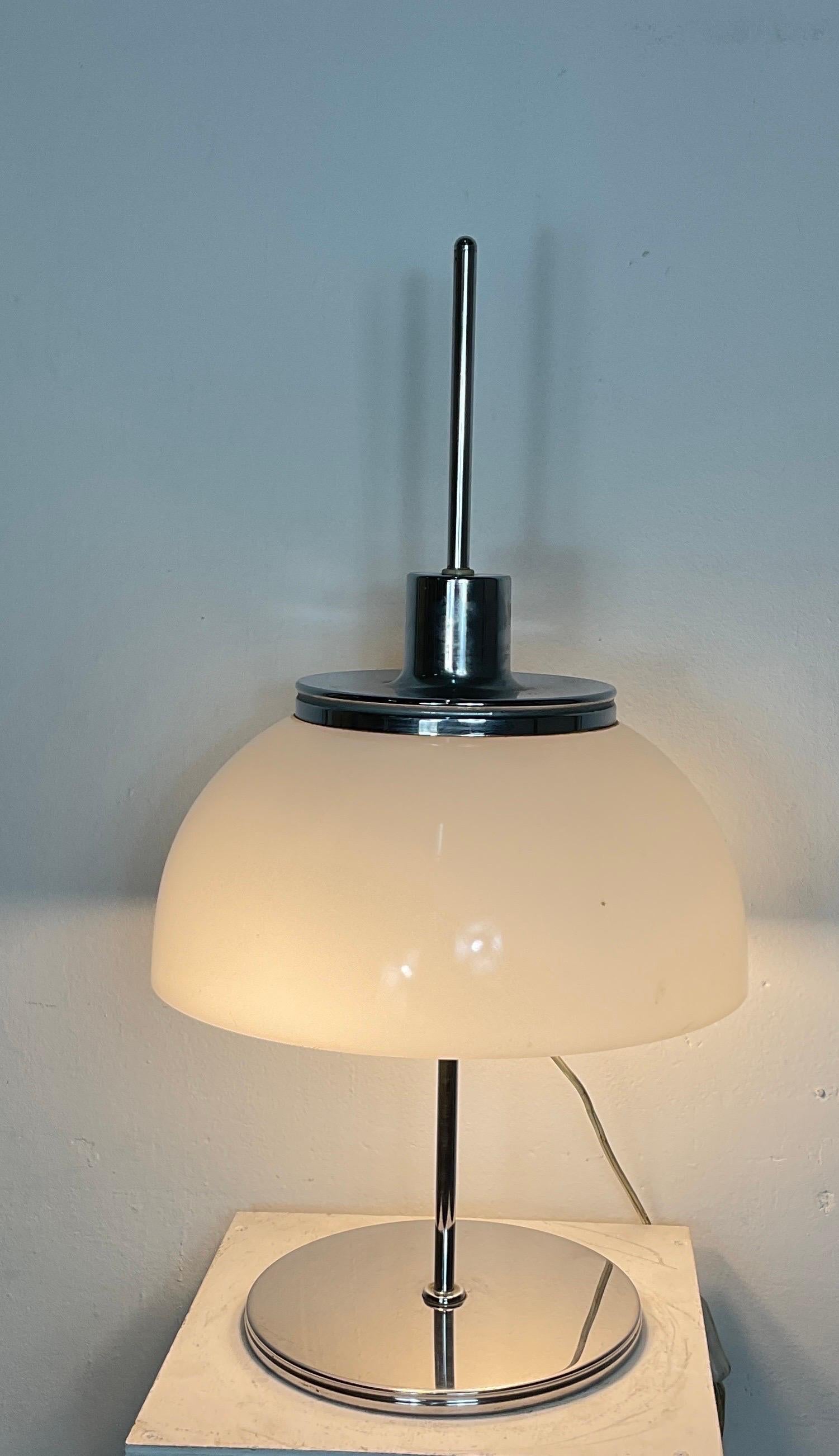 Rare Italian table lamp designed by renowned Italian designer Harvey Guzzini.
Guzzini designed this lamp in the 1970s for manufacturer Meblo. 
 
The lamp has a round chromed iron base. Chrome rod and white acrylic round mushroom. 
