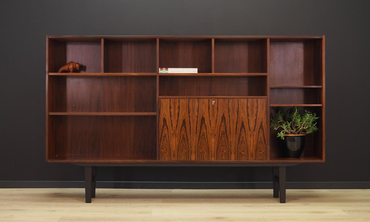 Superb bookcase / library from the 1960s-1970s. Scandinavian design, Minimalist form. Manufactured by Farso. Furniture finished with rosewood veneer. Bookcase has numerous shelves and a practical bar. Key included in the set. Maintained in good