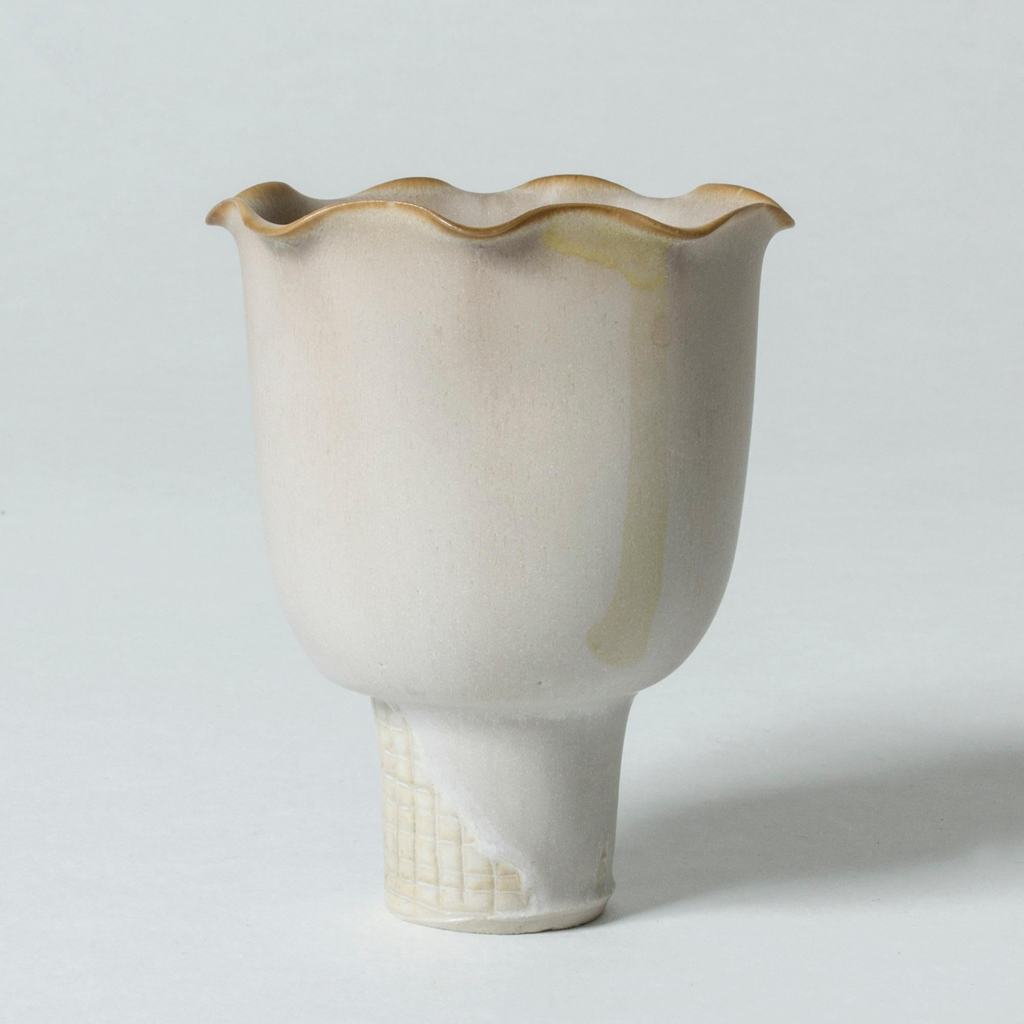 Lovely, small stoneware “Farsta” vase by Wilhelm Kåge. Beautiful wave-shaped rim and checkered base that is partially glazed. Eggshell white glaze.

“Farsta” stoneware is recognized as being the best and most exclusive that has come out of Swedish