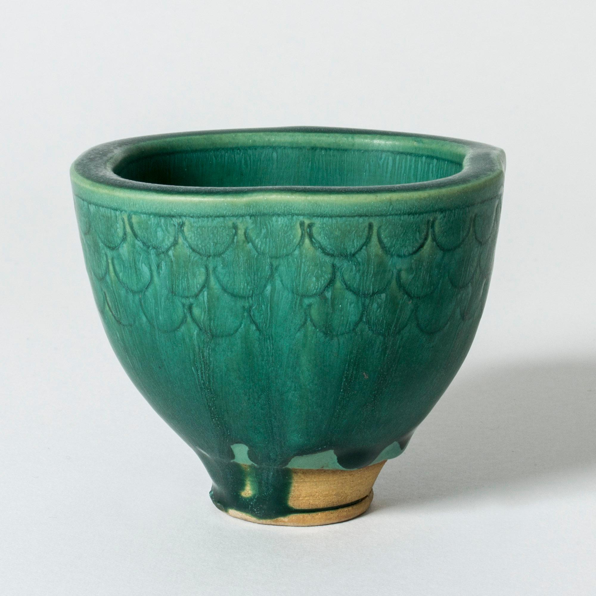 Lovely “Farsta” vase by Wilhelm Kåge in a small design with thick sides. Beautiful scalloped pattern and rich green glaze running over the body, gathering in drops around the base.

“Farsta” stoneware is recognized as being the best and most