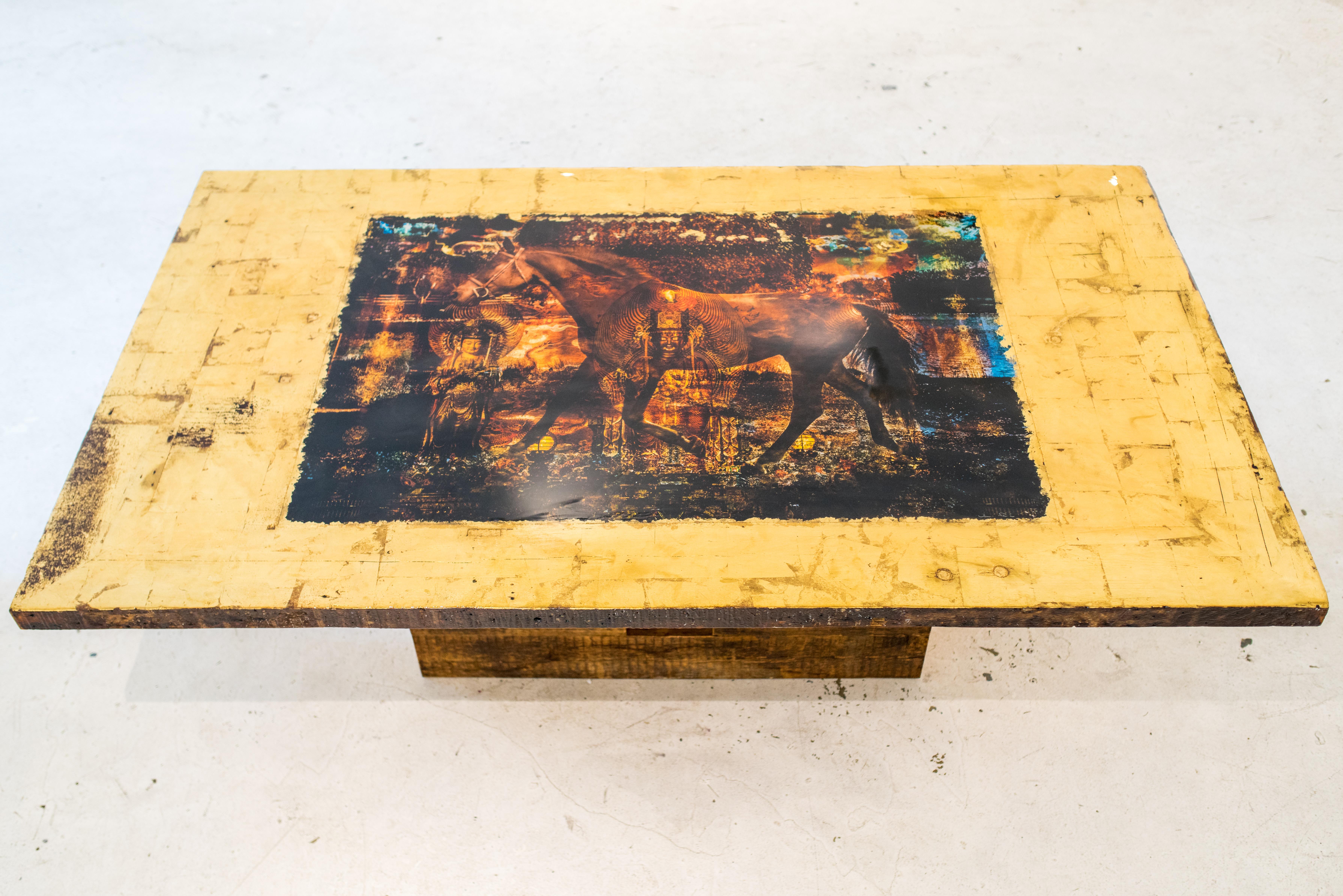 La table Collaboration a été réalisée en collaboration avec l'artiste canadien Daniel Stanford. L'œuvre d'art incorporée dans la table est un mélange unique de photographie avec des éléments de collage et une application précise de feuilles d'or,