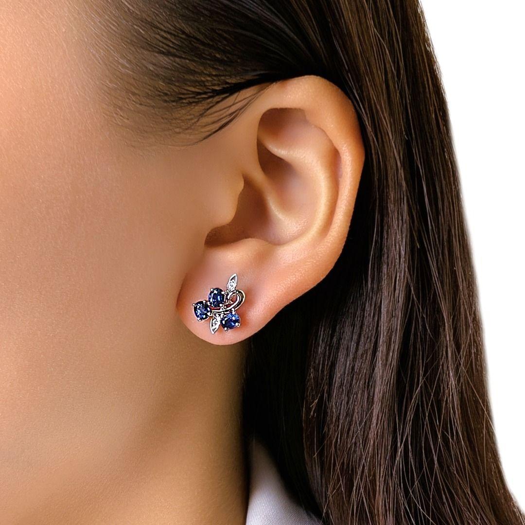 Questi orecchini di ispirazione floreale presentano 6 zaffiri blu dal taglio ovale (0,6 carati in totale) disposti in un morbido grappolo a forma di petalo, accentuato da 4 diamanti tondi brillanti (0,02 carati), di colore H e purezza SI.