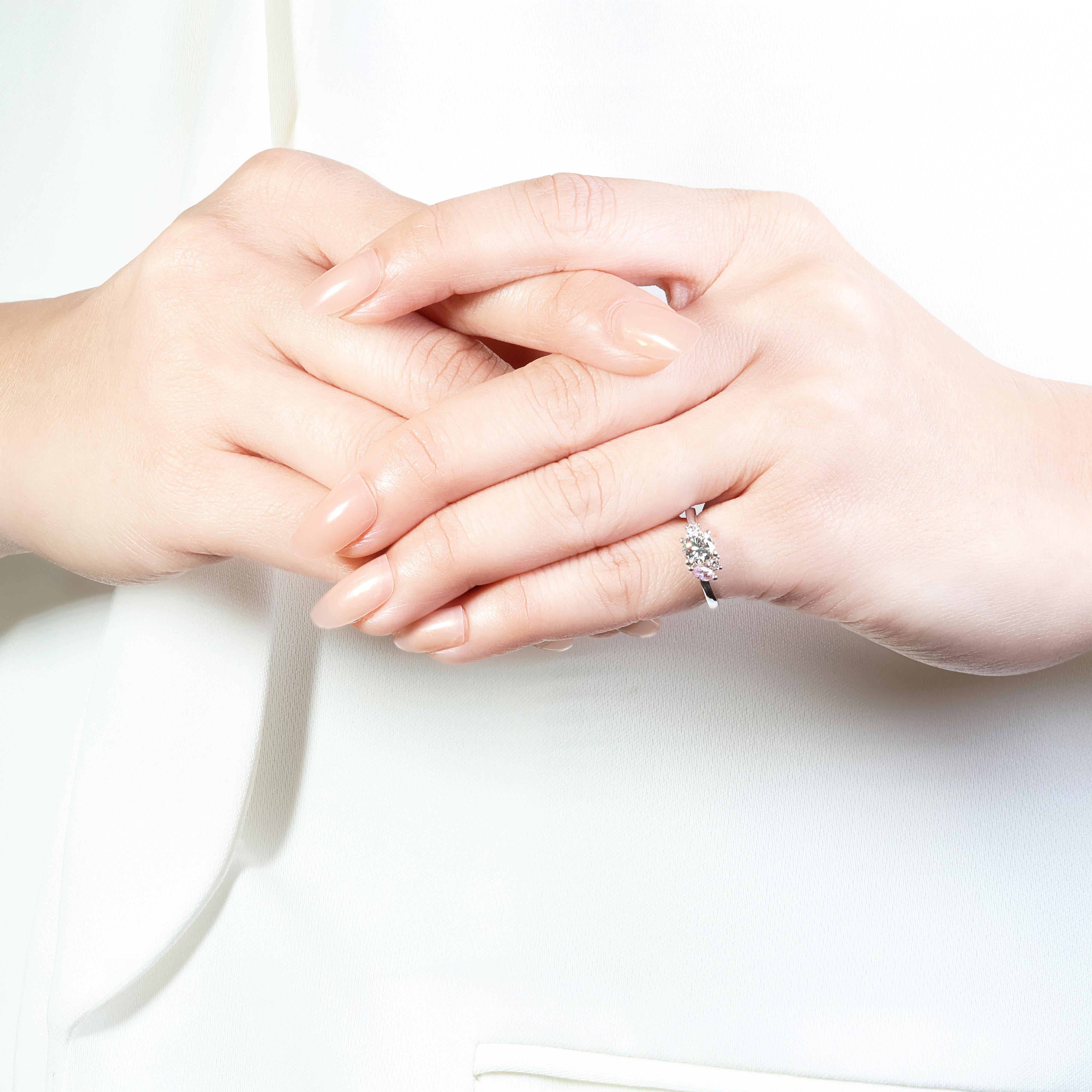 This captivating 18k white gold ring features a delicate 0.07ct marquise-cut pink tourmaline, showcasing a soft and feminine hue. The tourmaline is elegantly accented by a shimmering round brilliant diamond weighing 0.55ct, boasting a brilliant K
