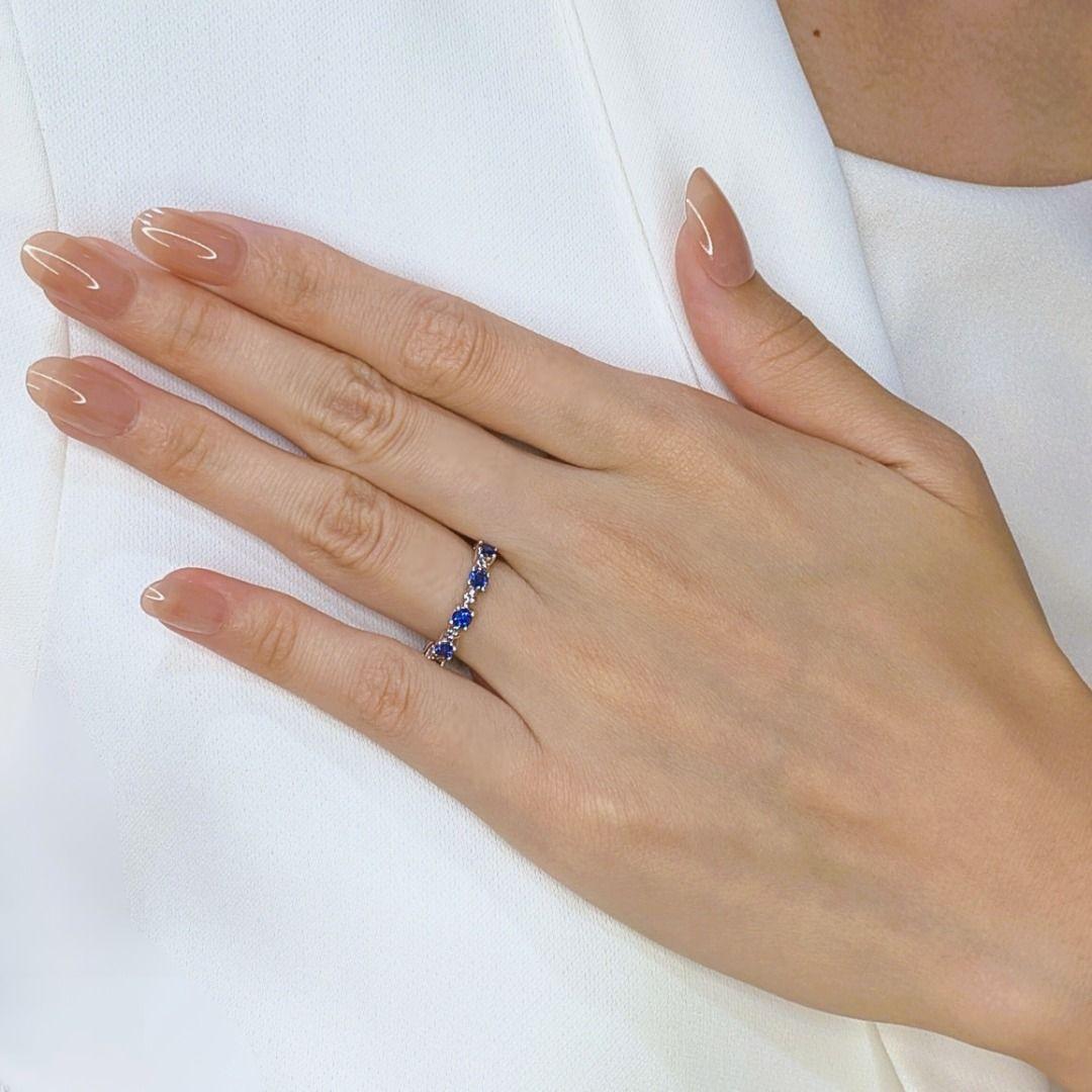Exuding sophistication and charm, this new, unworn Lee Hwa ring is a true embodiment of elegance. Crafted in 18K white gold, it features seven mesmerizing round brilliant sapphires, totaling 0.7 carats, each radiating a rich blue hue that captures