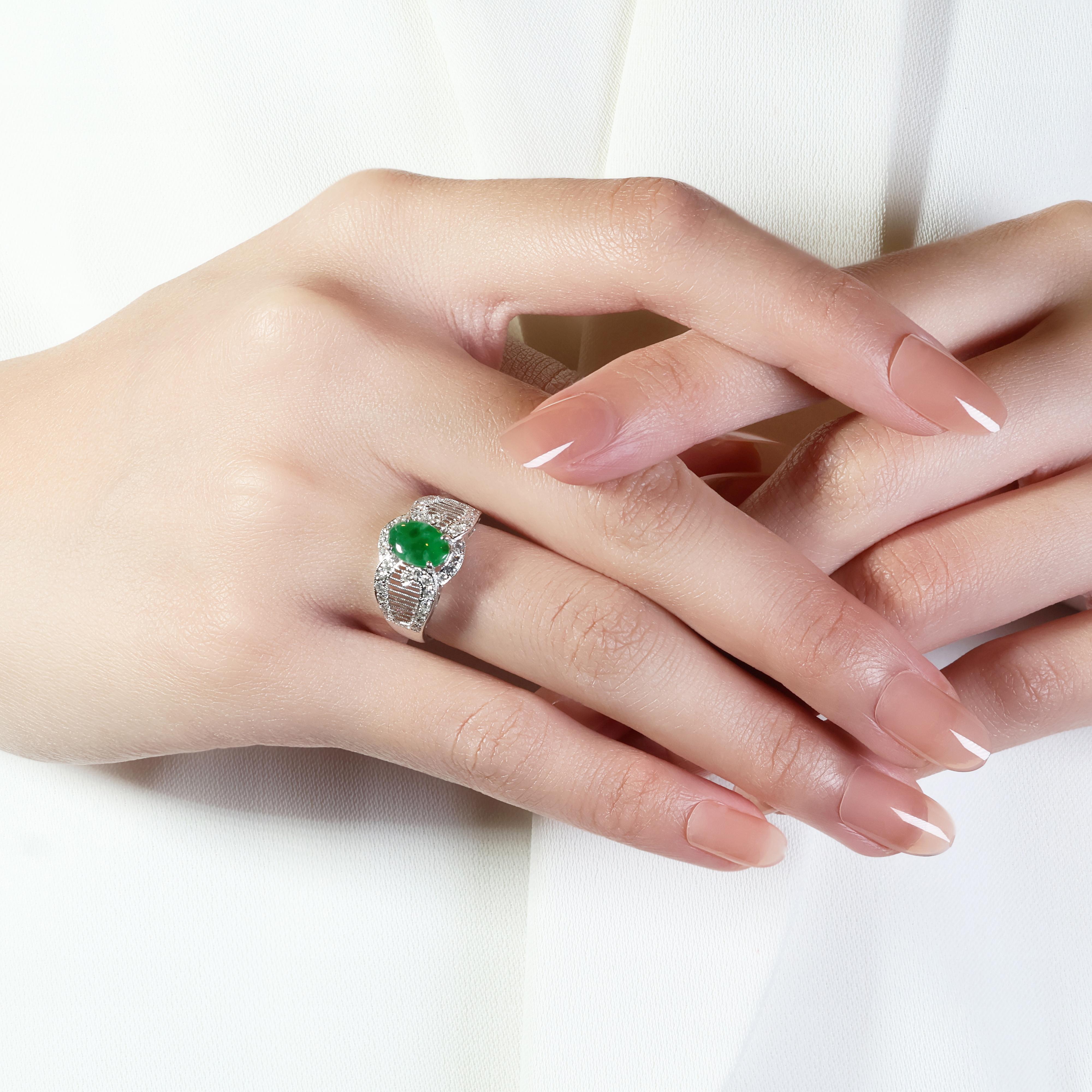 This stunning 18k white gold ring is a masterpiece of design. A captivating 1.15-carat oval jade stone, showcasing a vibrant green hue, takes center stage. The ring's elegance is amplified by a dazzling halo of 38 round brilliant diamonds, totaling