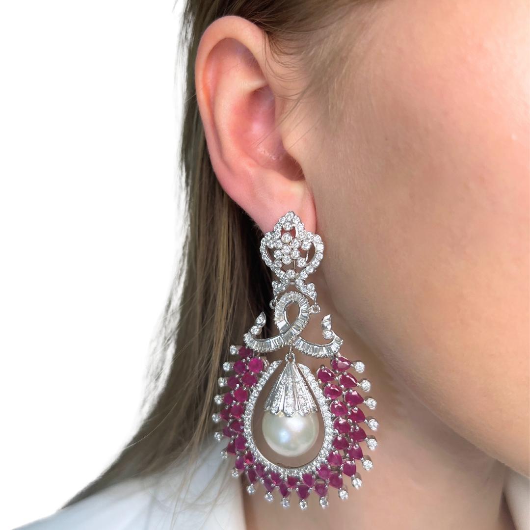 Fascinating 47.82ct Rubies, Salt Water Pearls, and Diamonds Drop Earrings in 18k White Gold - IGI Certified

These magnificent 18k white gold drop earrings are a true masterpiece, combining 76 dazzling purplish-red pear-shaped rubies totaling 11.20