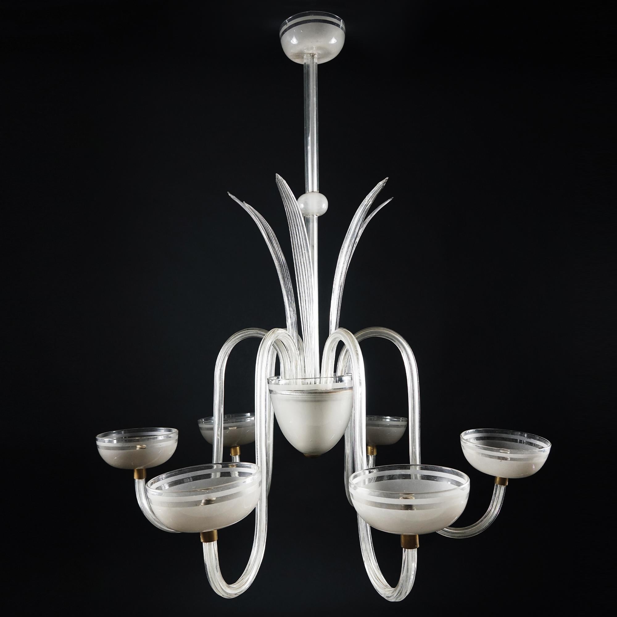Venini chandelier in partly frosted clear glass with six lights emerging from scroll arms; linear stem, six leaves pointing upward. Piece of great refinement. In the background works by Taeko MIma.
