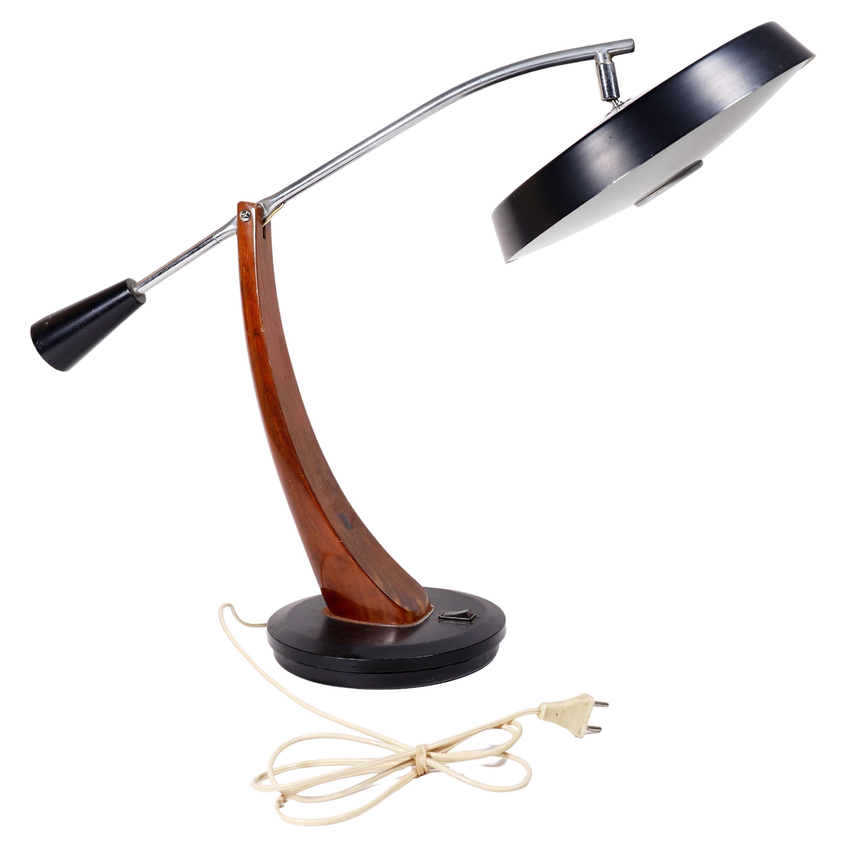 Desk lamp designed by Fase Madrid in the 1960s, comes in a black finish. A counterbalance mechanism allows to adjust the height of the shade, which can also be articulated by a ball joint on its top. Original removable glass diffuser allowing access