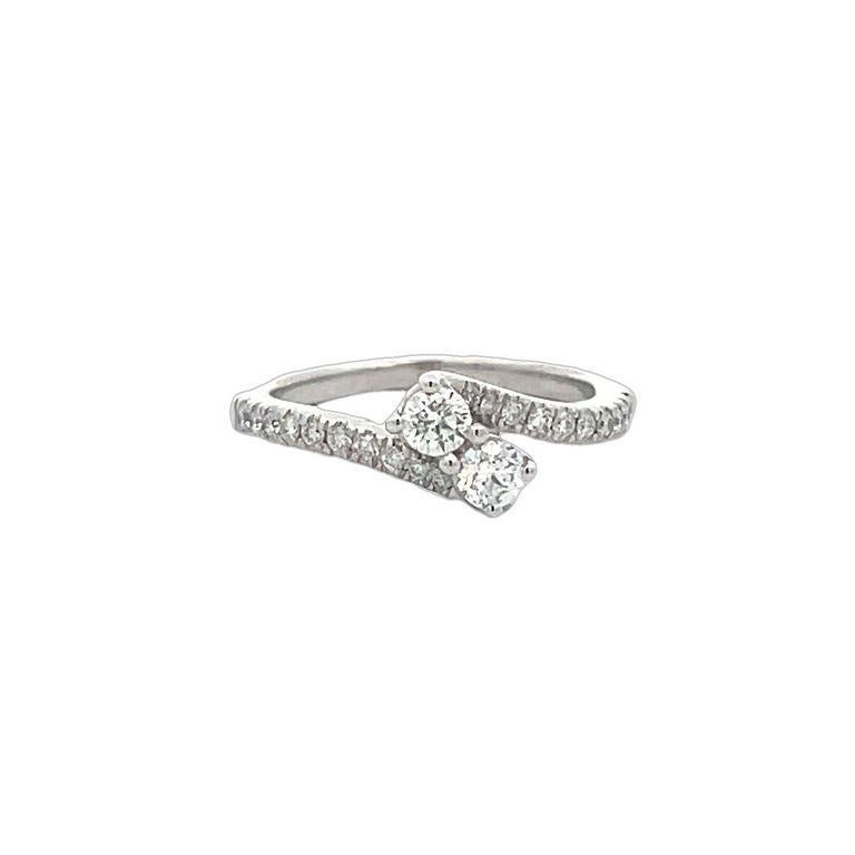 Questo squisito anello presenta due splendidi diamanti bianchi posizionati al centro, elegantemente circondati da una fila di diamanti più piccoli lungo la fascia. Il design emana un'eleganza senza tempo ed è abbastanza versatile da poter essere