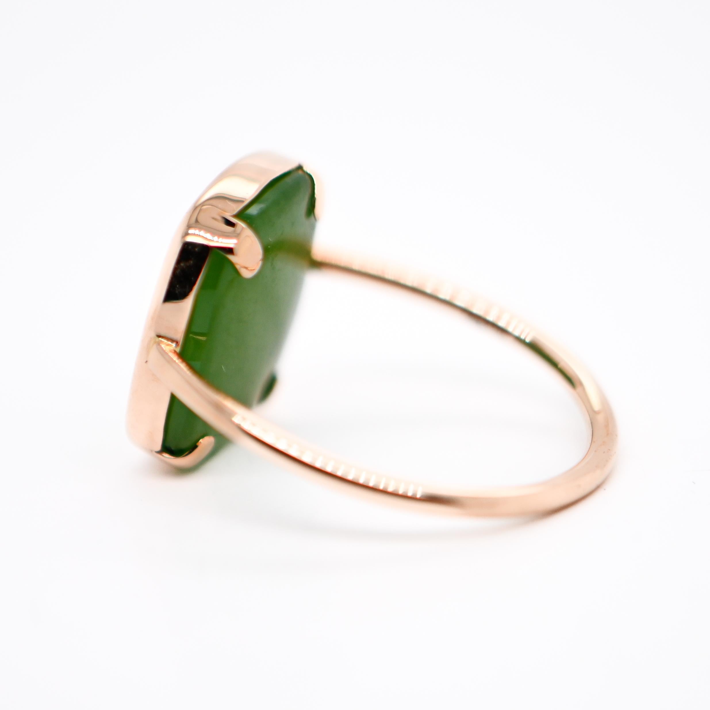 Entdecken Sie diesen schönen, modischen und modernen Ring aus Roségold, der sowohl zeitlose Eleganz als auch einen modernen Touch verkörpert. Dieser Ring, besetzt mit einem kostbaren Schatz der Natur, einem Jadestein von seltener Schönheit, ist die