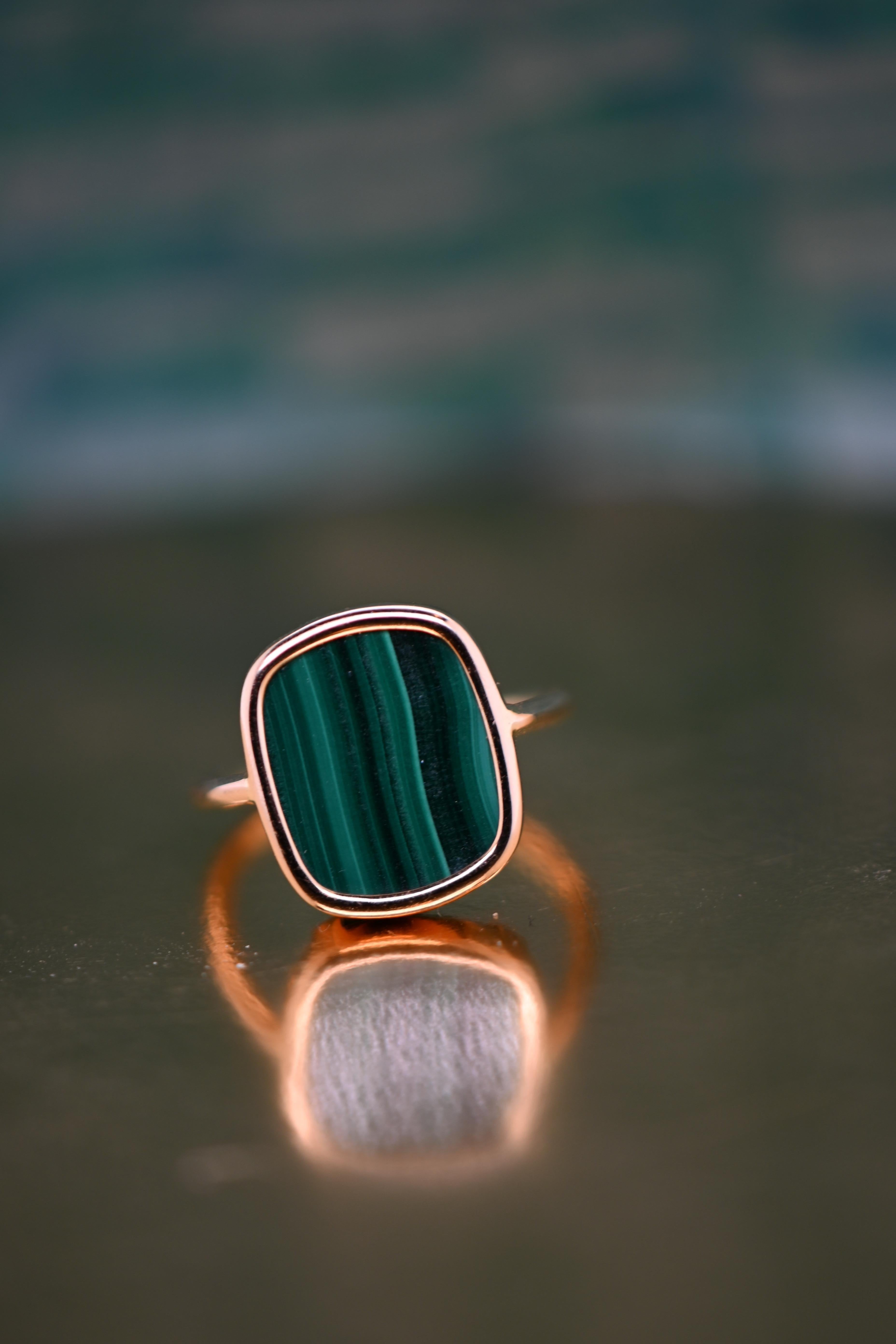 18k rose gold, a symbol of luxury and elegance, is crafted with meticulous craftsmanship to create this dazzlingly beautiful ring. Malachite, with its mesmerizing shades of green, lends a touch of sophistication and mystery to this creation. Each