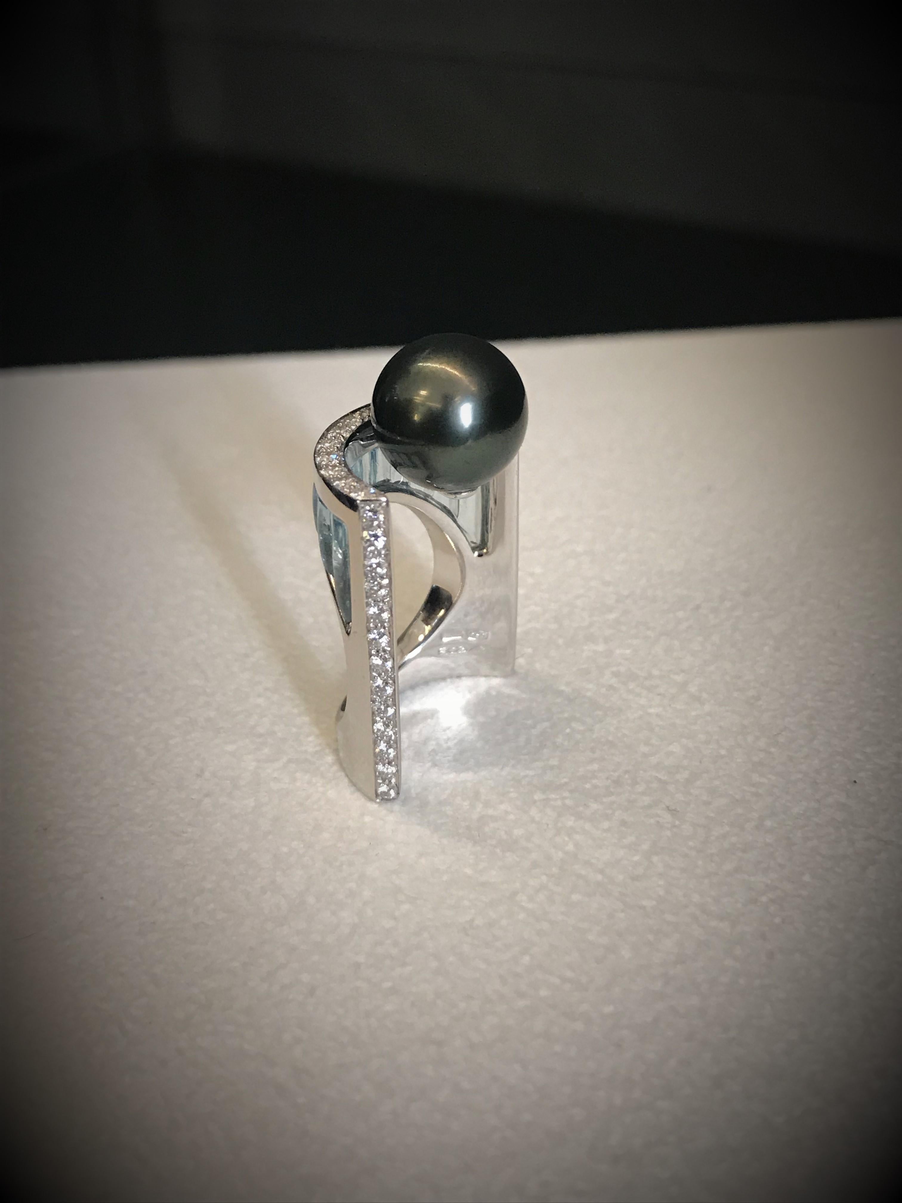 White gold shapes exalted by transparent inlay form an arch that sustain a stunning Tahitian pearl.

White gold, diamonds pavé,  Tahiti black pearl and blue topaz inlay. 

Diamonds ct 0.62
Topaz ct 5.00
Tahiti Pearl ct 12.25
Ring size: EU 13