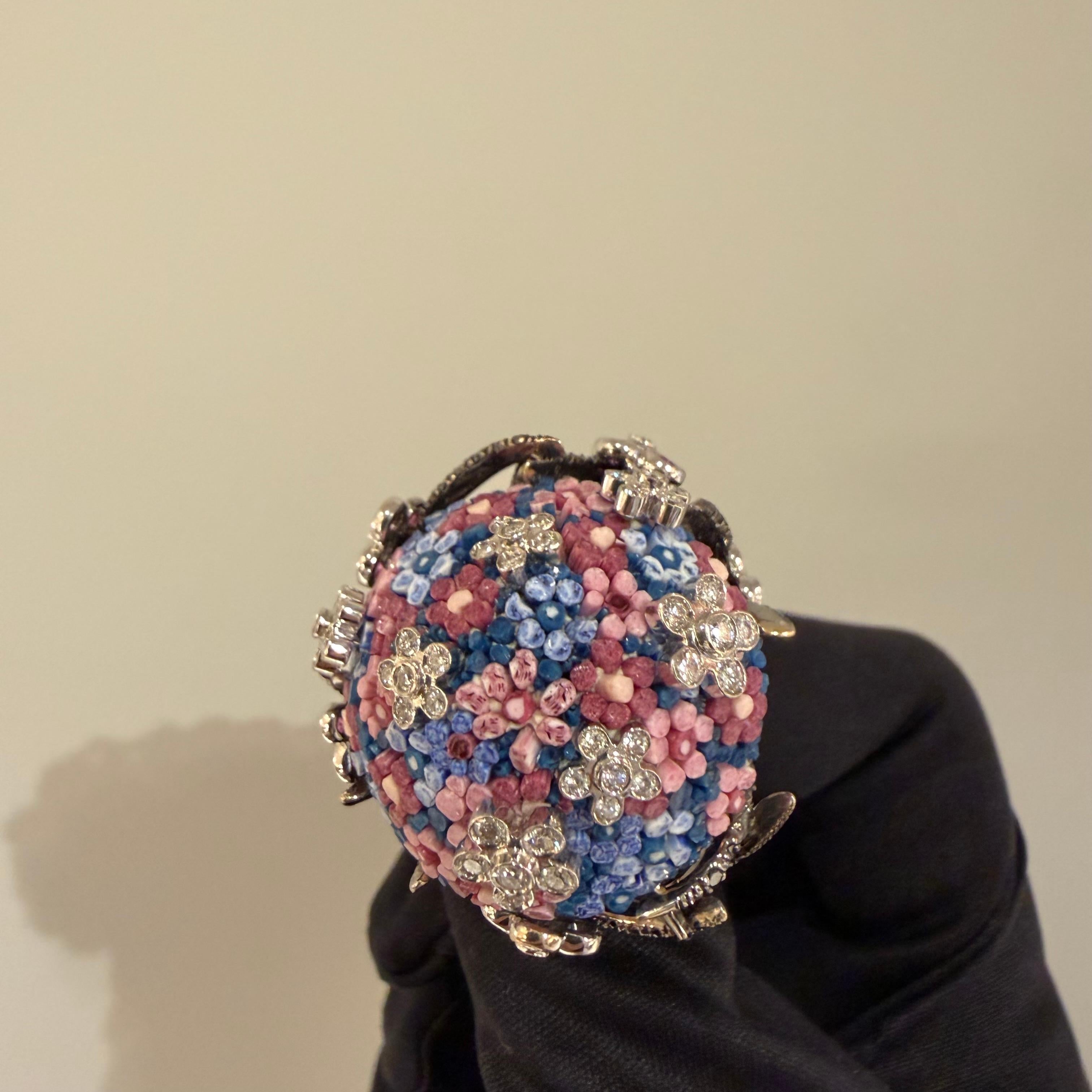 Gli artisti del micro-mosaico intrecciano minuscole bacchette di smalto veneziano ottenute dalla fusione ad alta temperatura di nove colori di base con polvere di diamante, realizzando infinite combinazioni di toni e sfumature. Le aste vengono poi