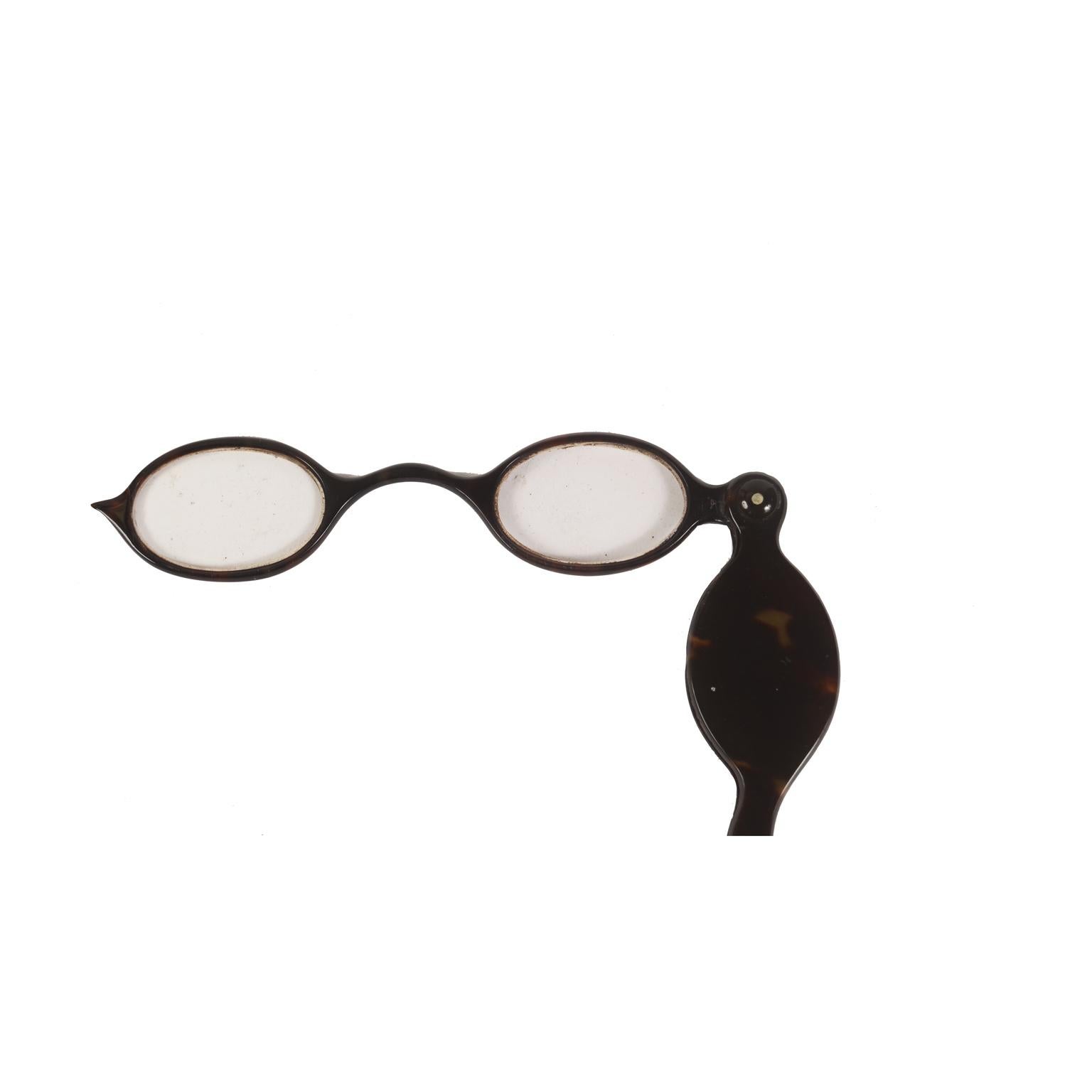 Fassamano (from the French face-a-main) eyeglasses with handle that turns into a case shaped like the lenses; dark tortoise eyeglasses, oval lenses that when not used fall back inside the handle. French manufacture of the second half of the 19th