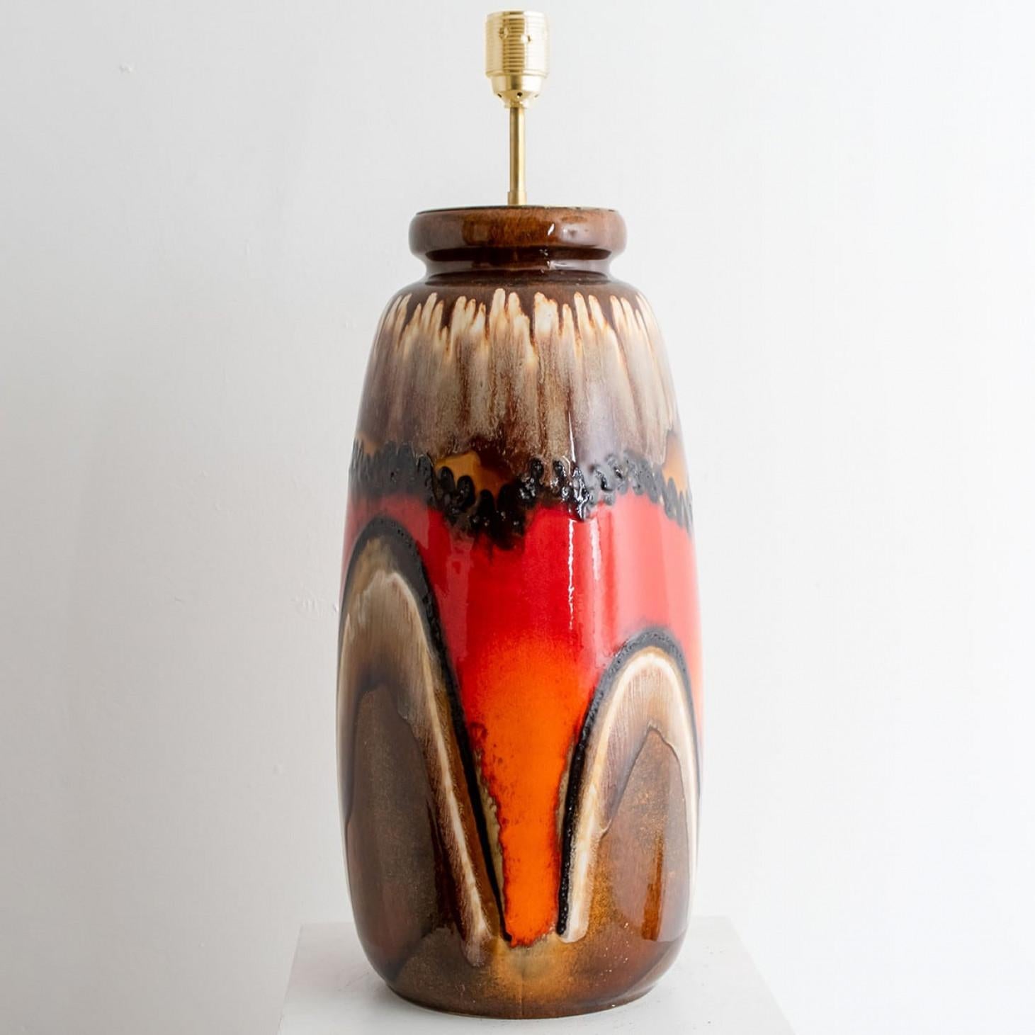 'Fat Lava' style ceramic table lamp with brown with red and orange glaze. Manufactured in West-Germany in the 1970's.
The style of the glaze is in between 'Fat Lava' and 'Drip glaze'. Which means the glaze is thick on some parts, and one glaze runs