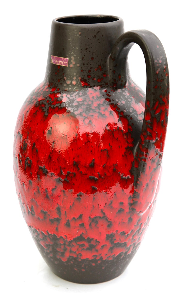 Classic fat lava red drip-glaze on charcoal background. Floor vase with handle. 
Vintage Scheurich with original label.
Glazed pottery.
Stamped on the base. 279-38, W-Germany.
Measures: 38 x 23 cm 2,9 kg
The piece is in excellent condition and