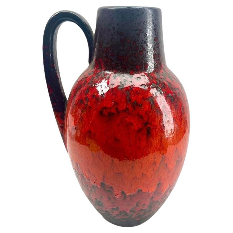 Classic fat lava red drip-glaze on charcoal background. Floor vase with handle. 
Vintage Scheurich with original label.
Glazed pottery.
Stamped on the base. 279-38, W-Germany.
Measures: 38 x 23 cm 2,9 kg
The piece is in excellent condition and a