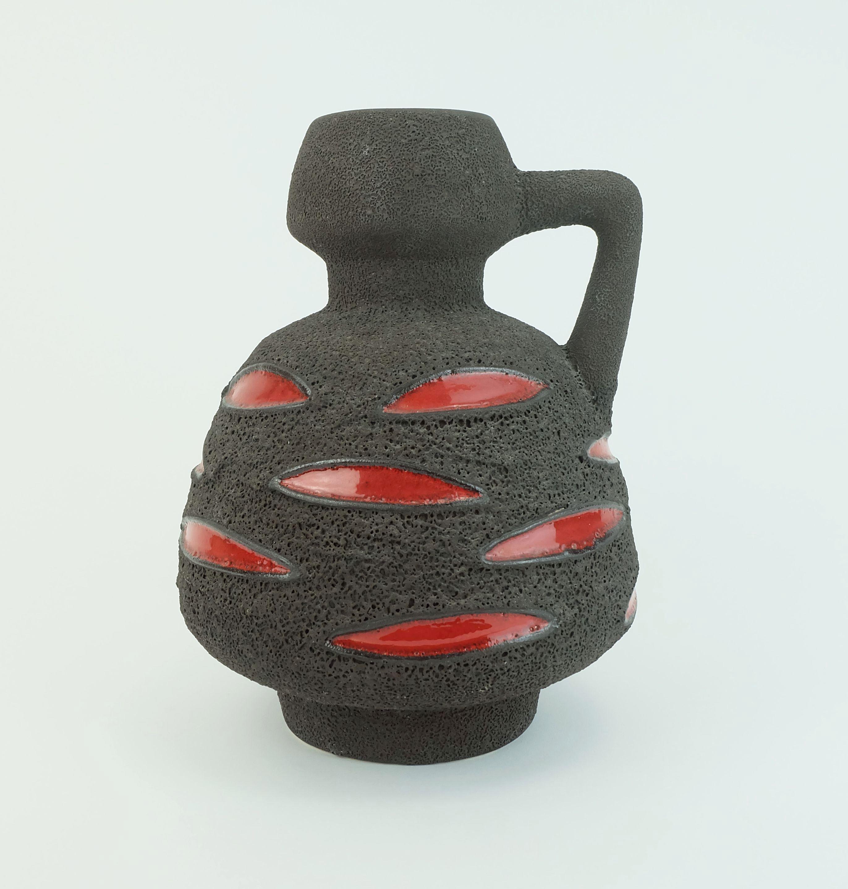 Vaso in ceramica della Germania occidentale con un'eccezionale smaltatura di lava grassa marrone crostosa e una sorta di motivo a foglie in rosso lucido. Prodotto da Schlossberg-Keramik negli anni '70. Model No. 64-25. 

Dimensioni in cm: 
Altezza