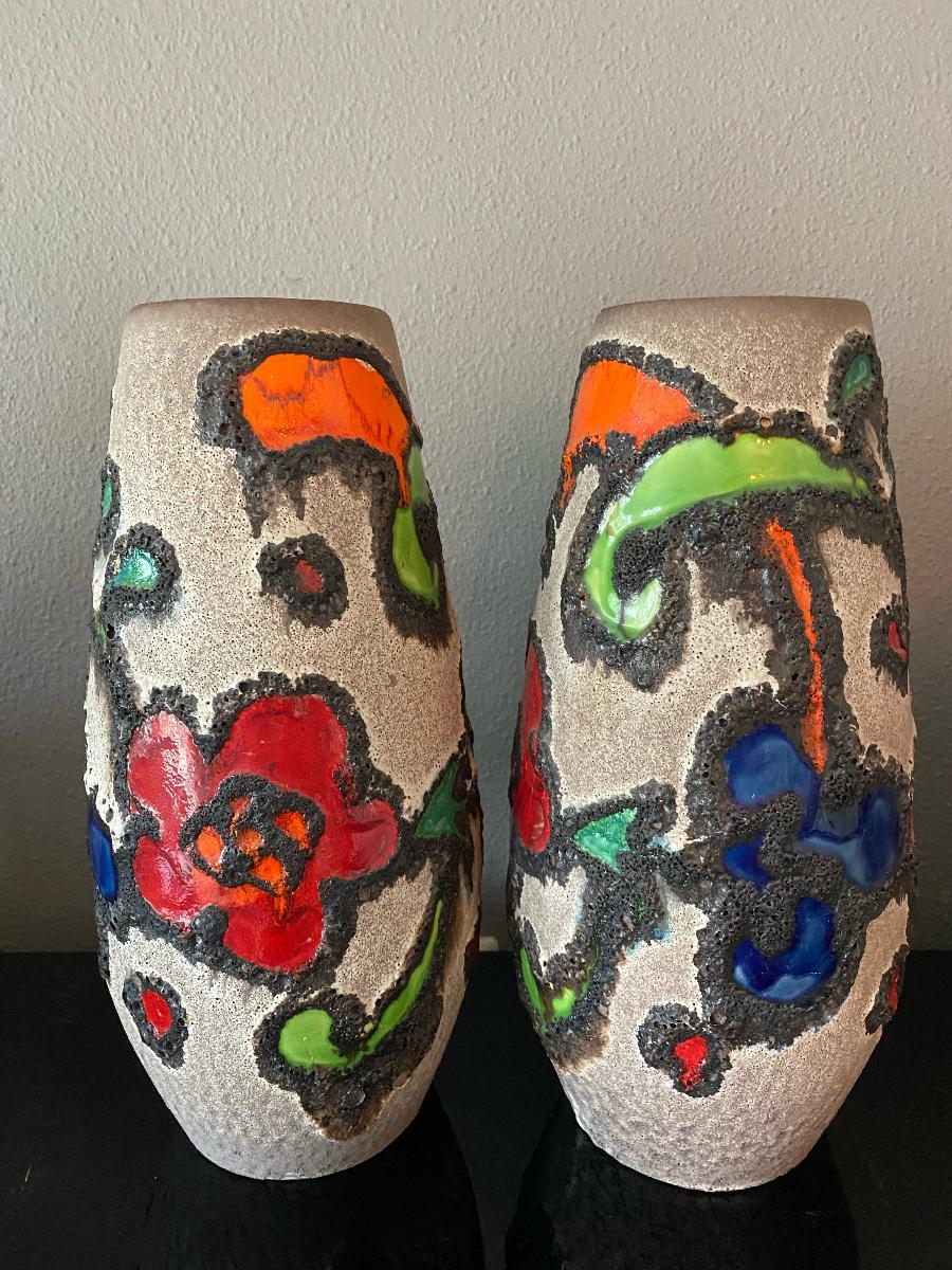 Two stunning colored vases from the seventies. Made of ceramic pottery in fat lava optic with abstract flower illustration in very strong colorations of red, blue, orange and green glaze.