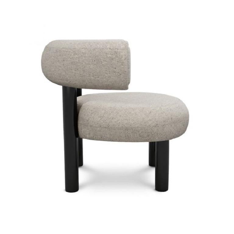 Designed to hug the body and allowing for multiple sitting positions, this lounge chair is upholstered using Bute's white woolen fabric. Fat is made from moulded foam with a metal leg launching in high gloss black lacquer and made to order