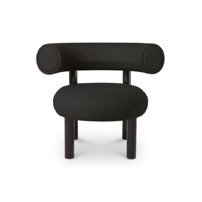 Designed to hug the body and allowing for multiple sitting positions, this lounge chair is upholstered using Bute's black woolen fabric. Fat is made from moulded foam with a metal leg launching in high gloss black lacquer and made to order