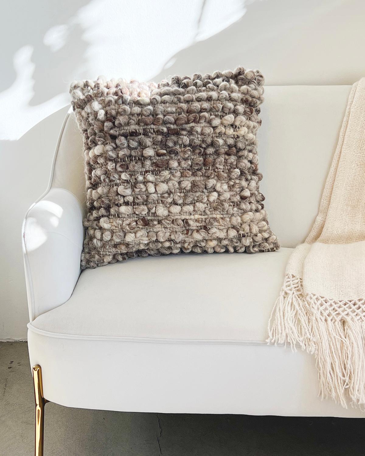 A textured throw pillow for your living room couch. This unique throw pillow features rows of bobbles (balls) made with 100% undyed sheep wool for a truly textured and cozy look. These cushions are handmade by Fatima in Portugal with wool from local