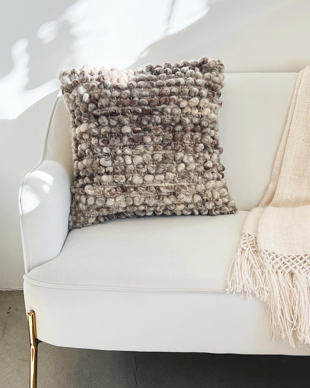 Un cojín con textura para el sofá de tu salón. Este cojín único presenta hileras de bolitas (bolas) hechas con lana de oveja 100% sin teñir, para un aspecto realmente texturizado y acogedor. Estos cojines están hechos a mano por Fátima en Portugal