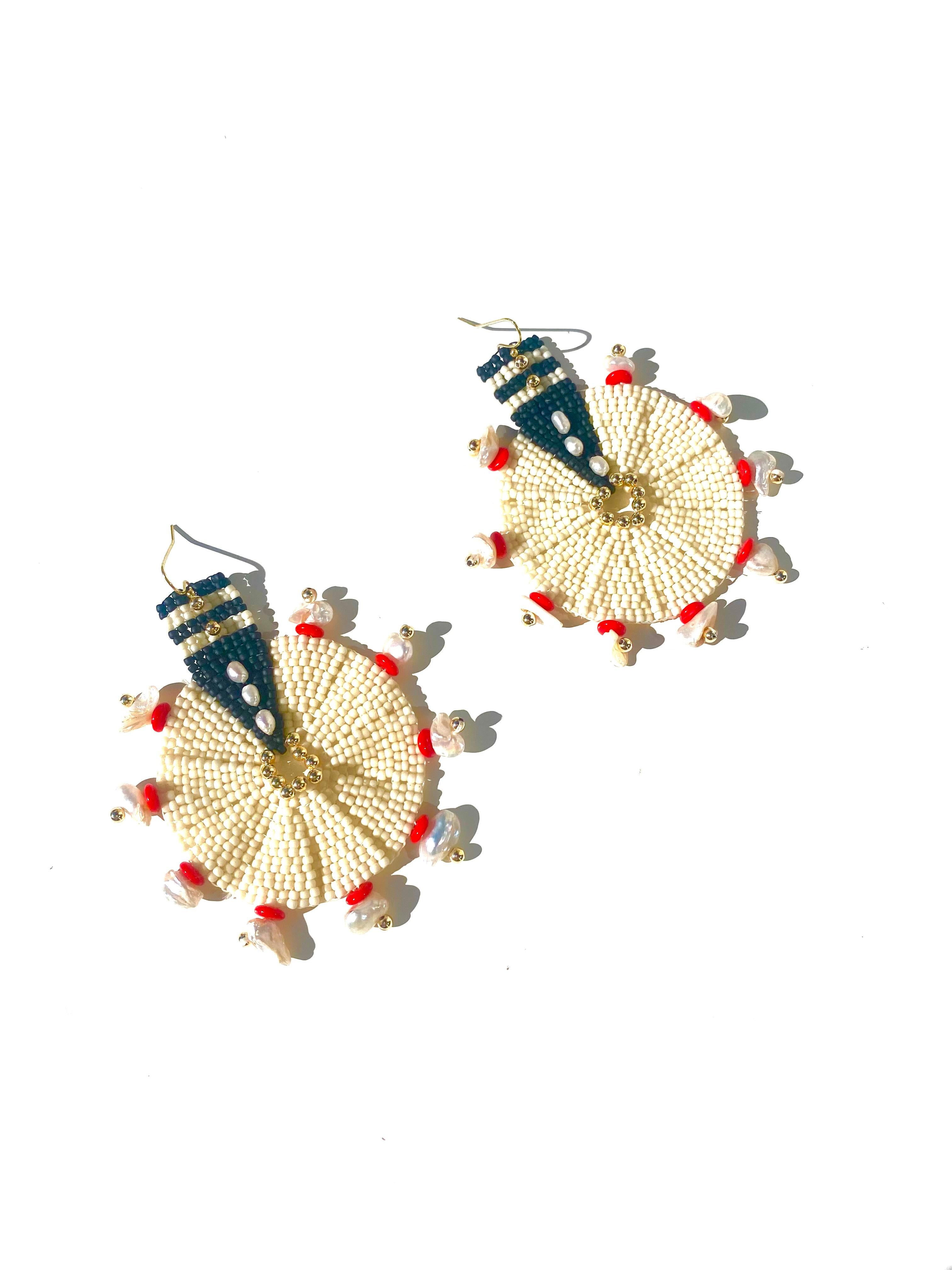 Handwoven Japanese black and ivory glass seed beads embroidered with 14k gold plated seed beads, fair trade red spacer beads and fresh water pearls. 14k gold filled earring hooks.