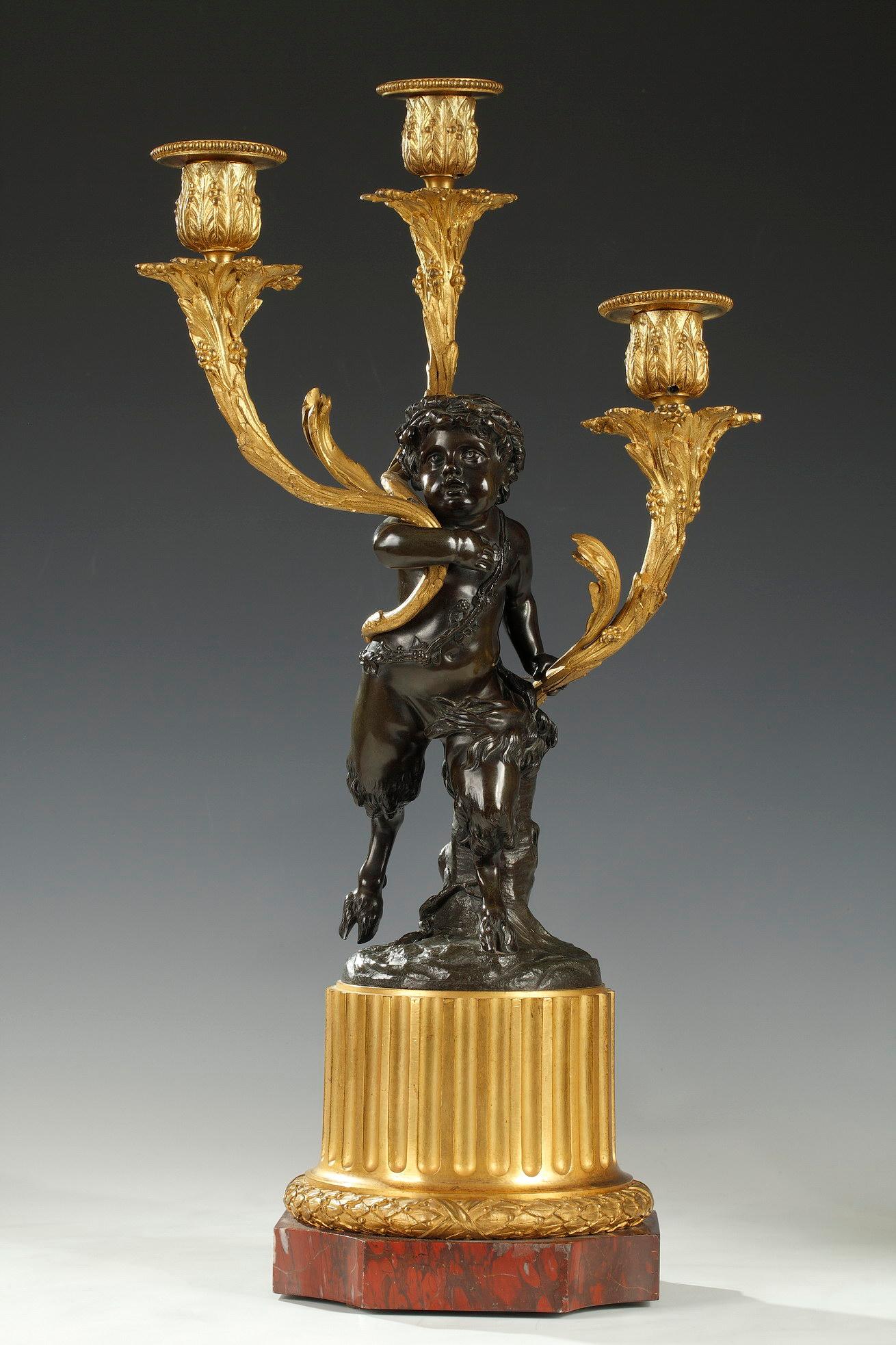 Pair of candelabras after a model by Clodion, representing a young Faun and a young Bacchus in patinated bronze, each holding three light-arms in chiseled and gilded bronze with vine decoration. They rest on a square base with curved edges in