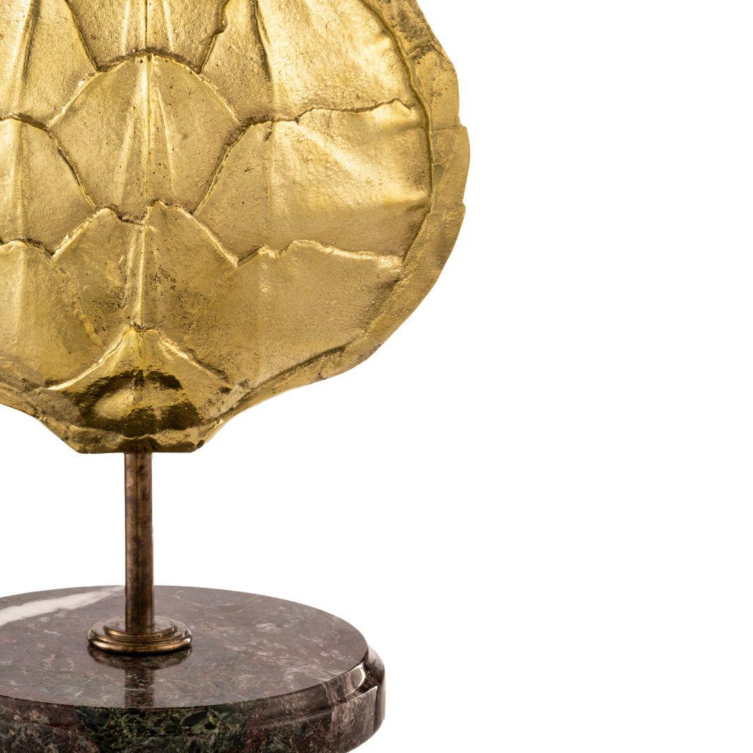 Cette lampe à poser appartient à la ligne Fauna de la collection Eclectic, elle présente une carapace de tortue en laiton moulé sur un socle rond en marbre brun Emperador et une finition en laiton ambré. L'abat-jour peut être personnalisé au niveau