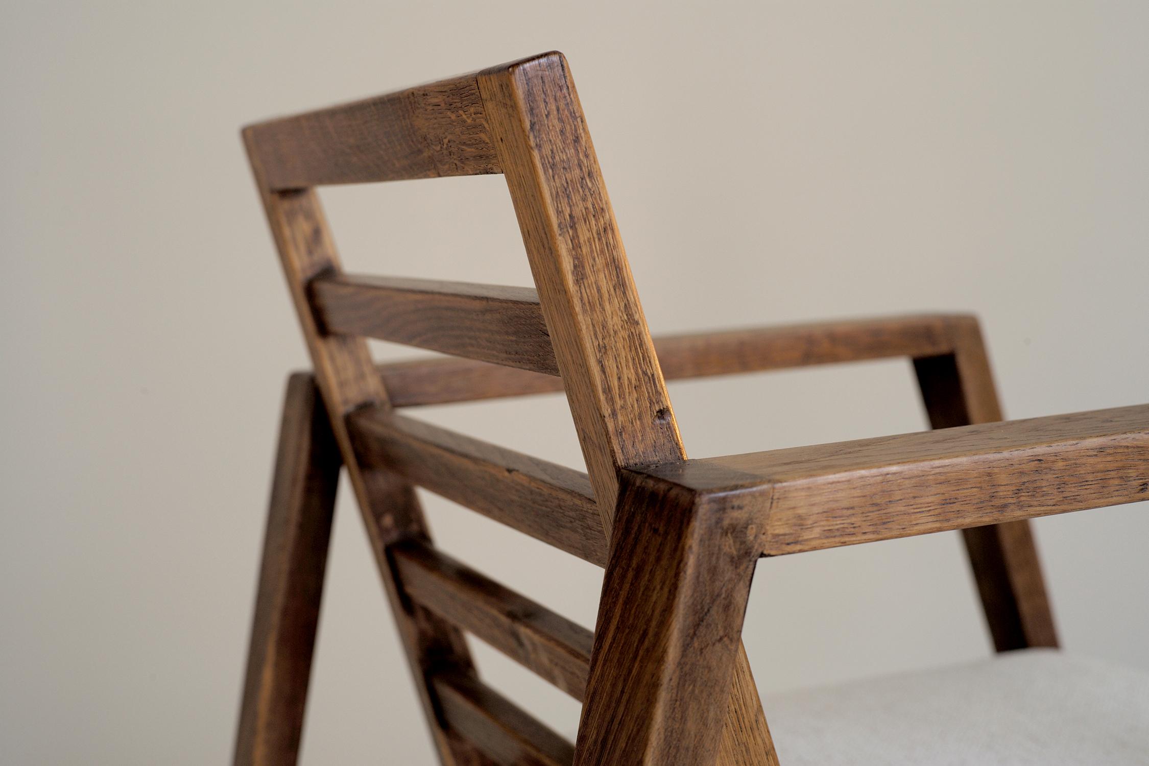 Seltene modernistische Sessel René Gabriel Eiche und Wolle Stoff gesprenkelt, Frankreich, 1950. Der Sockel aus zwei trapezförmigen Bögen nimmt die Sitzfläche und die Rückenlehne auf, die durch vier Abstandshalter unterbrochen werden. Dieser schöne
