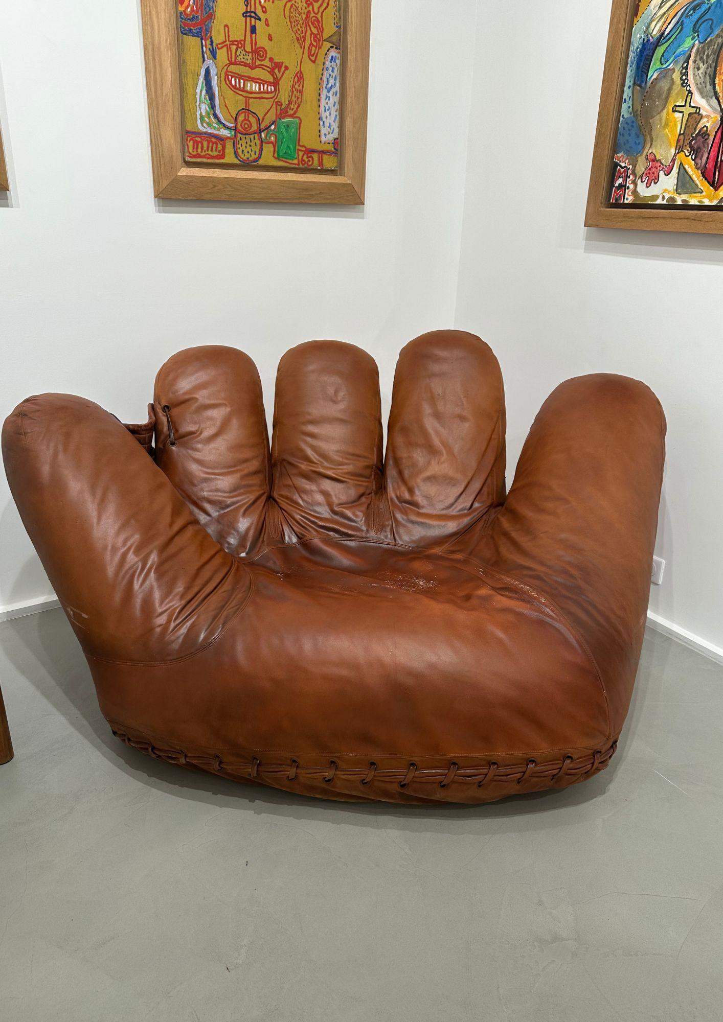 Fauteuil en mousse de polyuréthane moulée sur une structure métallique tubulaire et garni de cuir naturel.
cuir.
Assemblés à la structure à l'aide de lacets à la base.
Deux petites roulettes facilitent le déplacement de cette chaise.
Hommage au