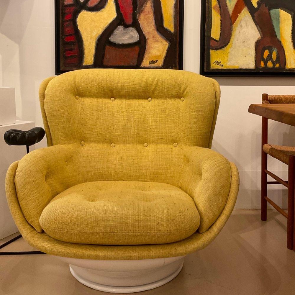 Sillón con carcasa de fibra de vidrio y asiento de tela.