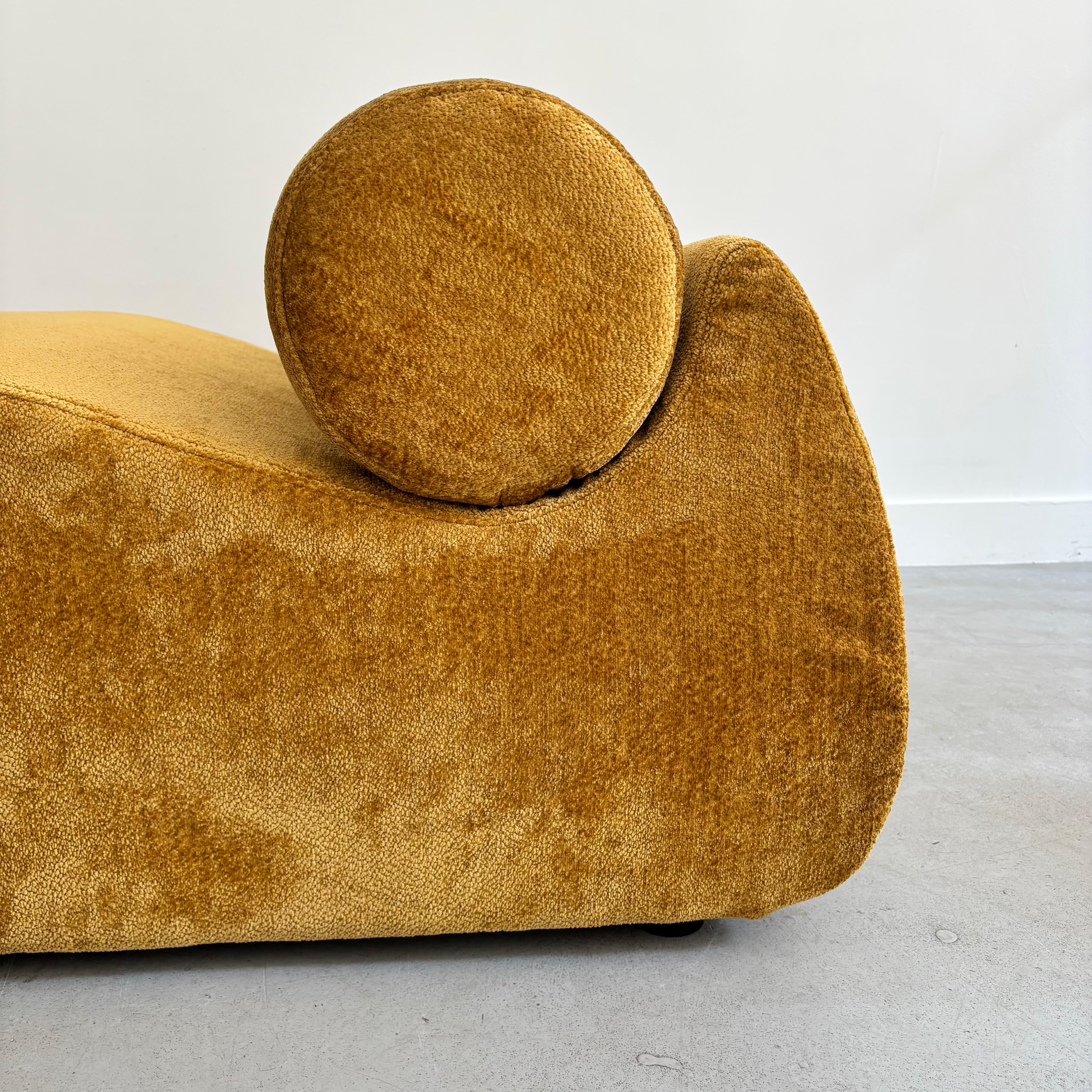 Fauteuil ocre en forme de virgule. Très graphique avec un petit coussin cylindrique.  En très bon état.