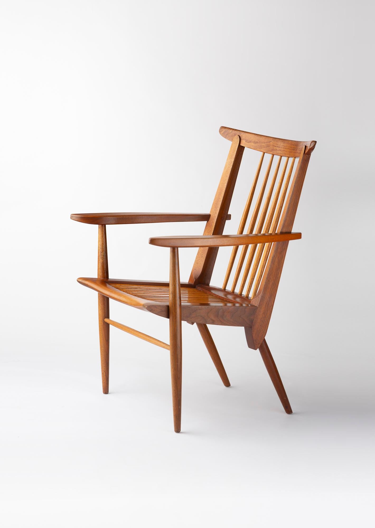 Este mueble, diseñado por George Nakashima, ilustra a la perfección su enfoque artesanal y poético de la madera. Realizada en madera maciza, combina líneas epoxi con una estructura ligera y equilibrada. El dossier de barras verticales y los