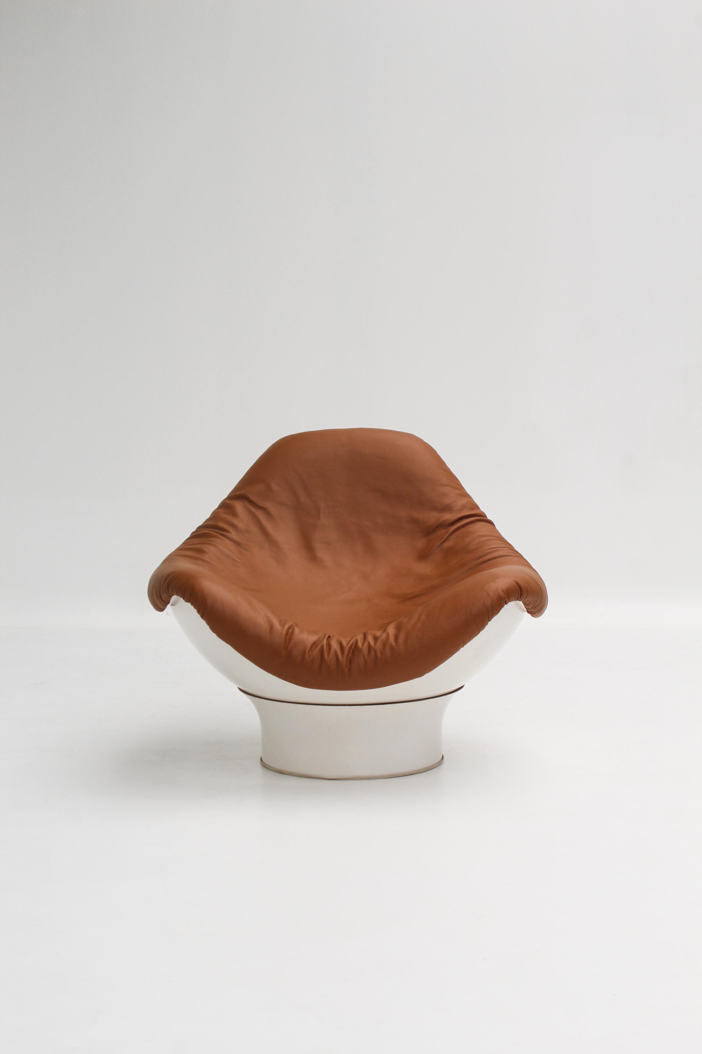 Conçu par Mario Brunu pour Comfort dans les années 1960, le fauteuil Rodica est une icône du design Space Age italien.

Sa coque en fibre de verre blanche abrite une assise enveloppante en cuir caramel, suspendue au-dessus de la base pivotante.

Le