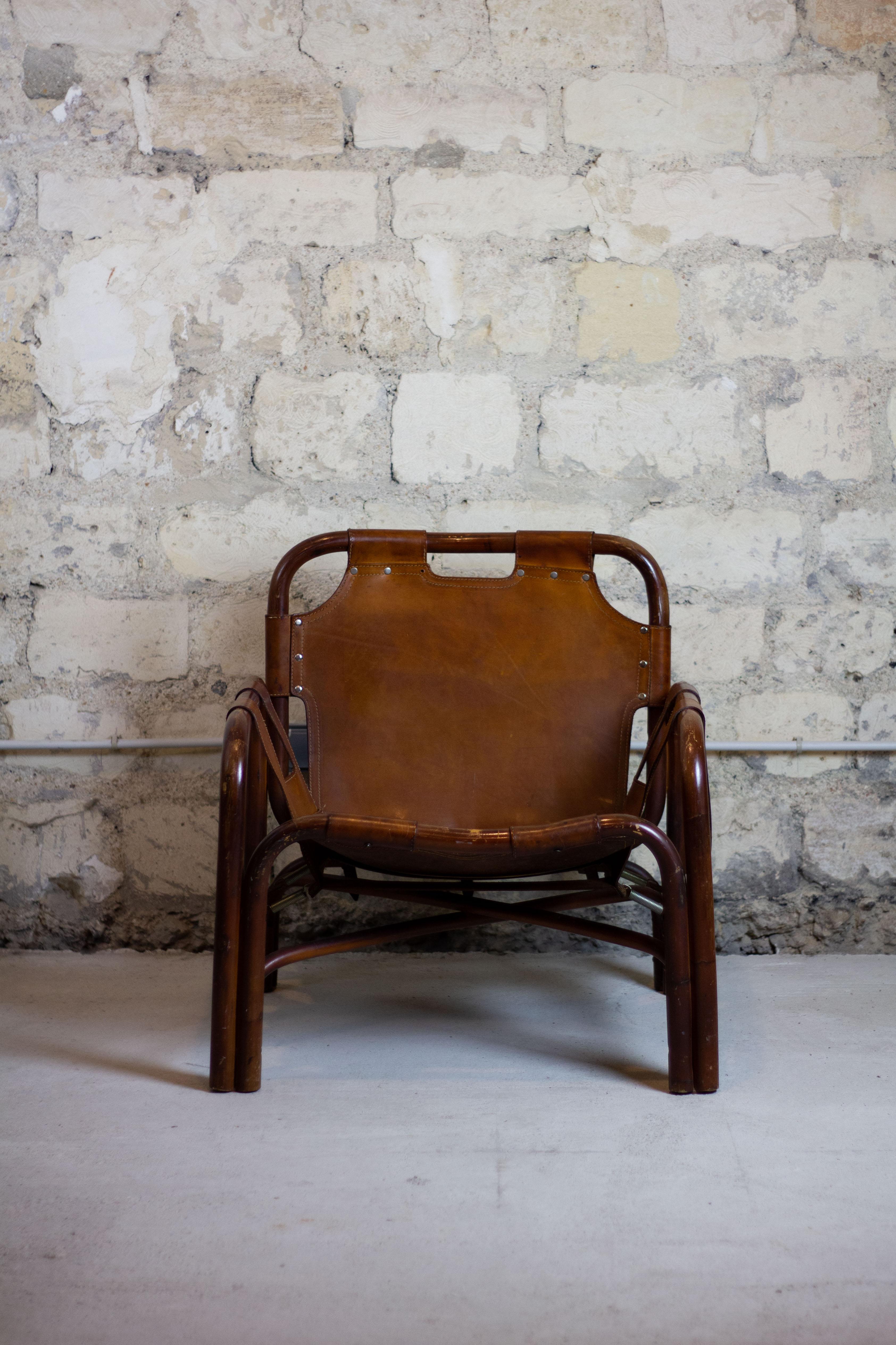 Le fauteuil safari vintage, conçu par le designer italien Tito Agnoli pour Bonacina dans les années 1960, dégage un sentiment d'aventure et une élégance intemporelle. Fabriqué à partir d'une combinaison de rotin et de cuir, ce fauteuil offre une