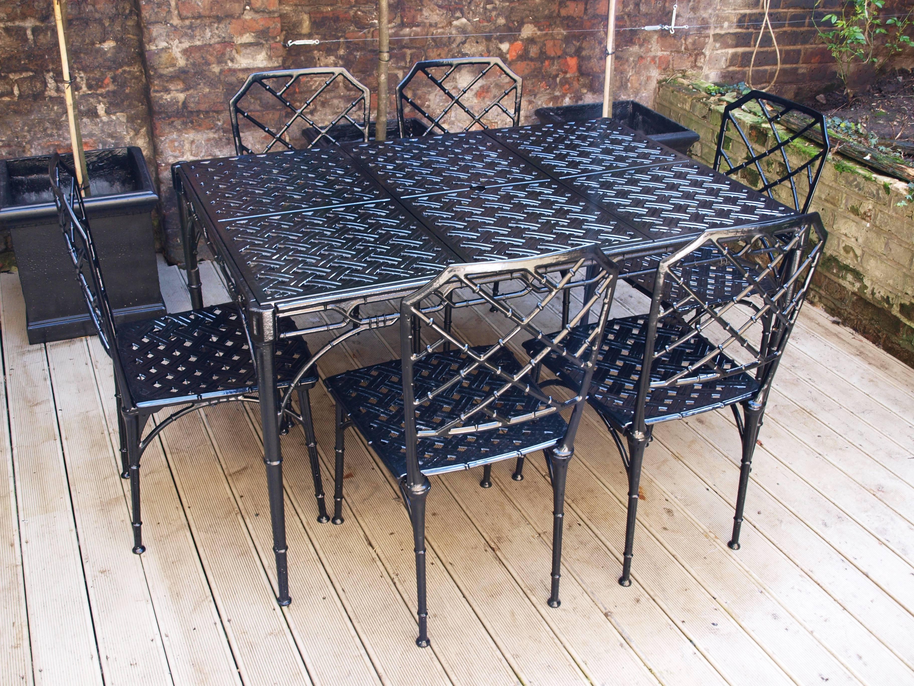 An elegant 1960s faux-bamboo seven-piece garden set in the style of the Brown Jordan, Calcutta Model. This set is in immaculate condition having undergone a full restoration and newly powder coated in black. 
The table features three removable