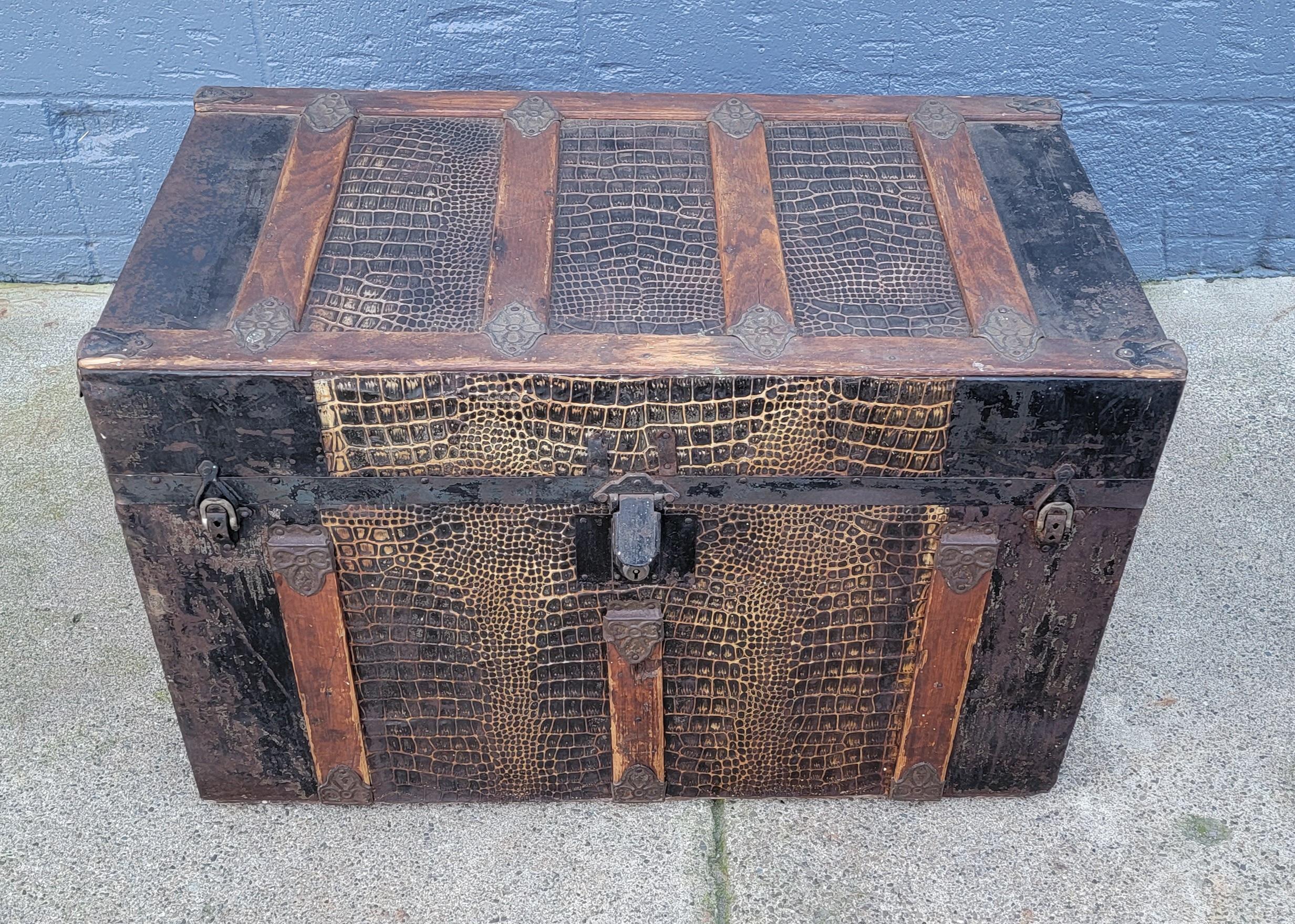 Rustic cabin trunk with faux alligator detail. Beautiful and warm patina to wood strapping and clad metal. Original paper lined interior with original tray. Old world charm with appropriate wear from history and use. Original, no touch-up or fixes.