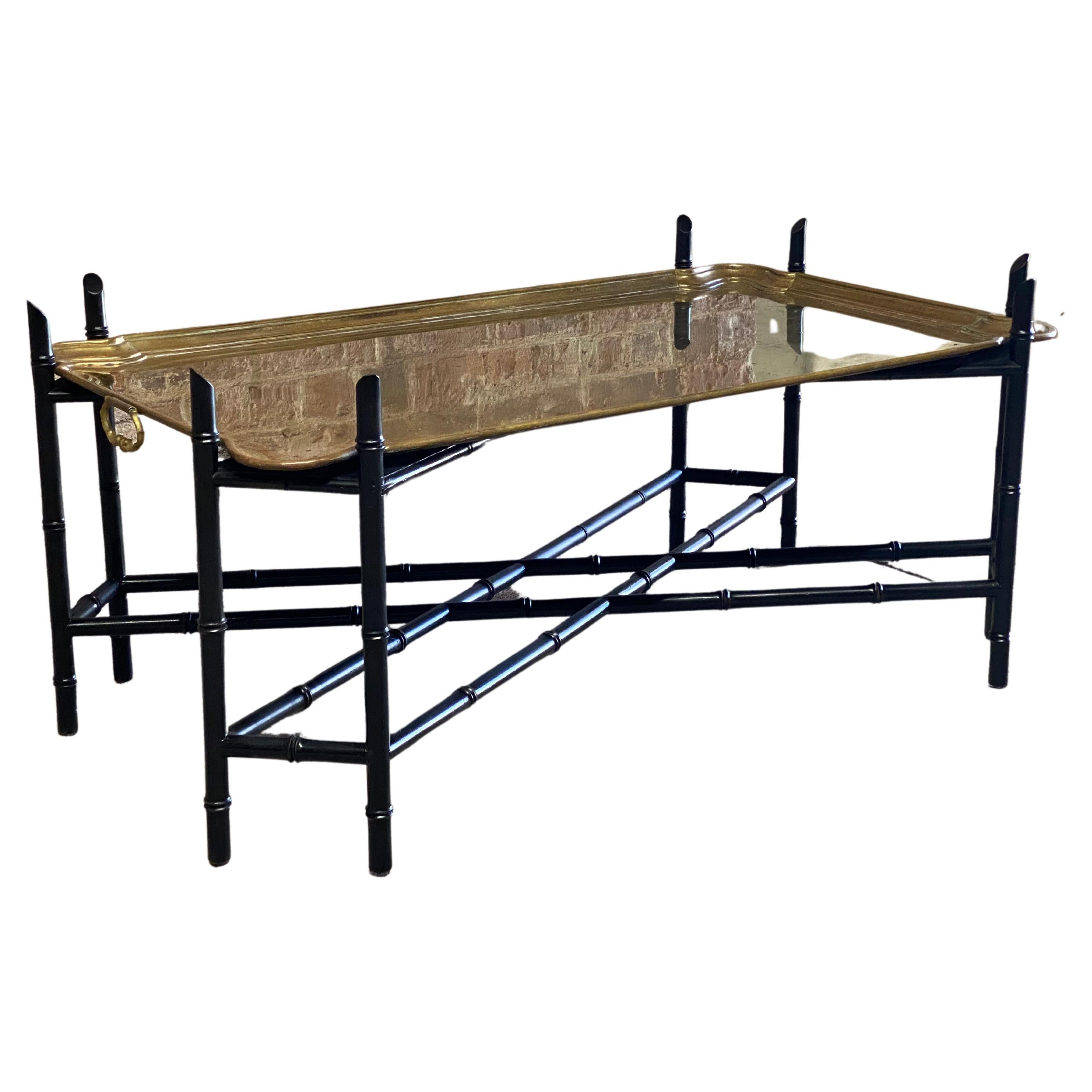 Faux bamboo wood base with a heavy duty solid brass shaped tray coffee table. The perfect accent piece for any style interior. Sturdy ebonized wood base with removable tray that has a nice snug fit. Circa 1960. Structurally sound and sturdy. The