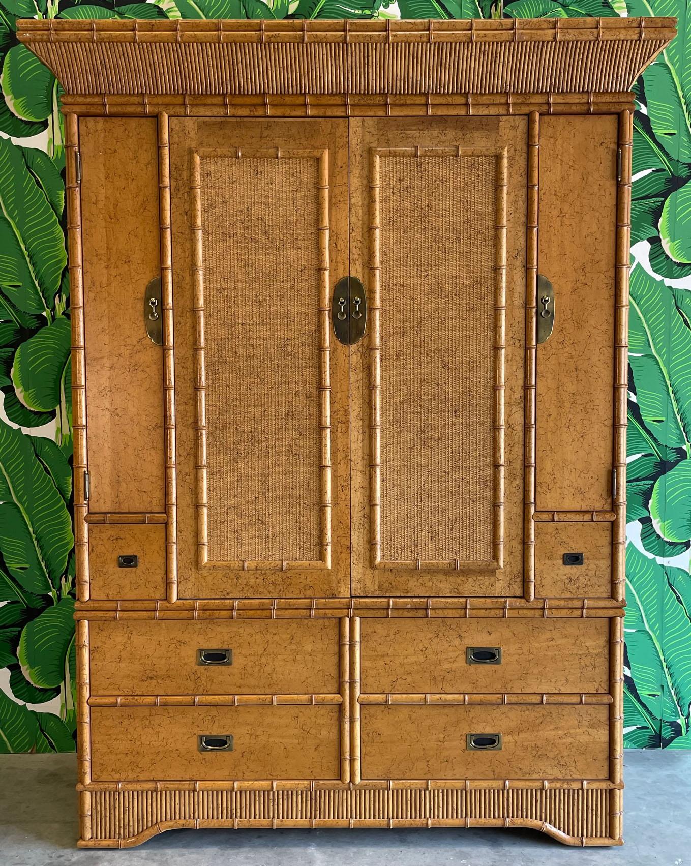 Large scale Asian inspired armoire designed by Miller Yee Fong for Ficks Reed. Features faux bamboo and cane detailing, brass hardware, and ample storage in four large drawers and hidden shelving. Very good condition with minor imperfections